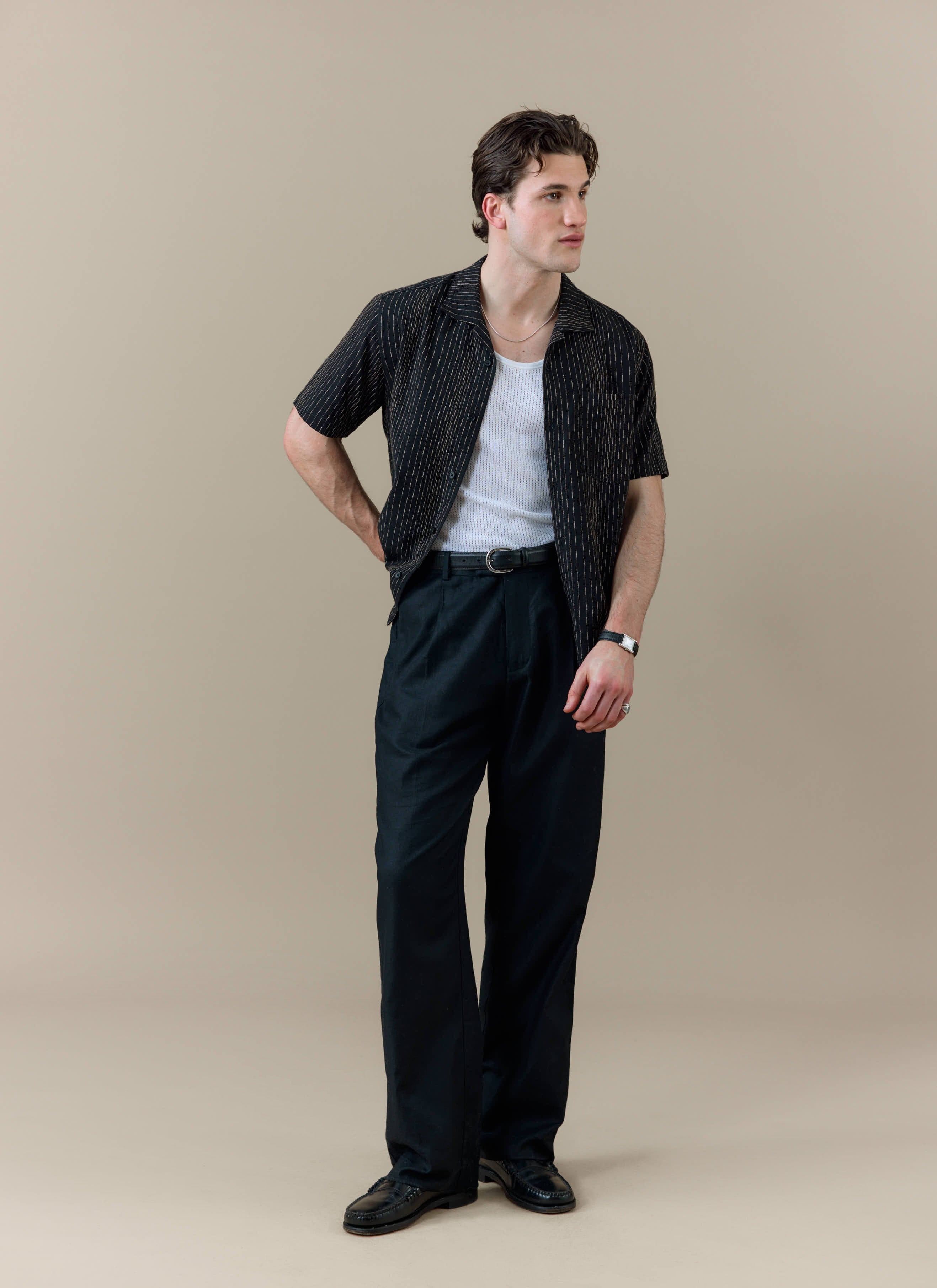 Model wearing the black Percival Leland Cuban Shirt with vertical stripe detailing and a classic Cuban collar.