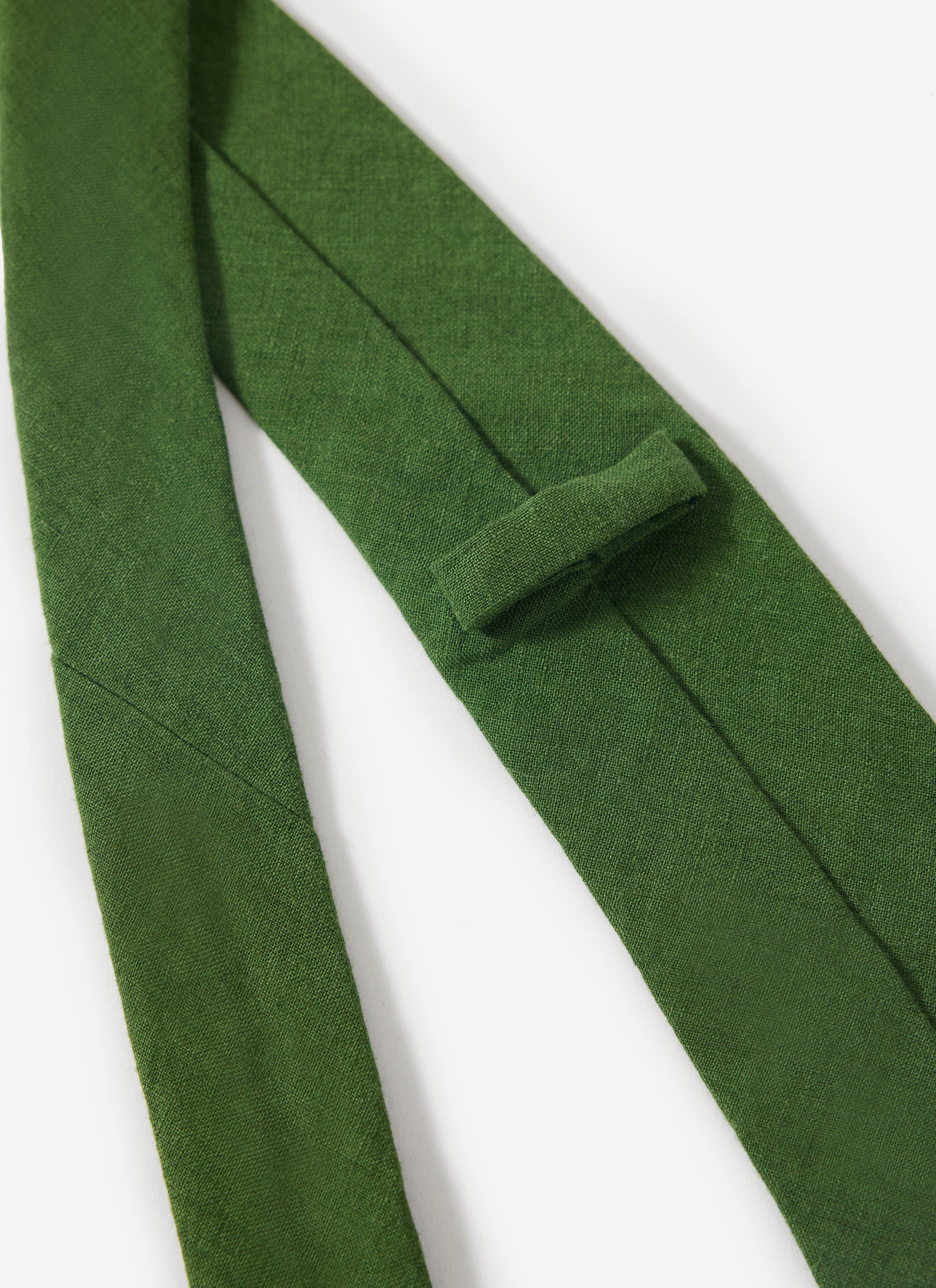 Close-up detail of the Percival forest green linen tie, highlighting the fabric's texture and keeper loop.