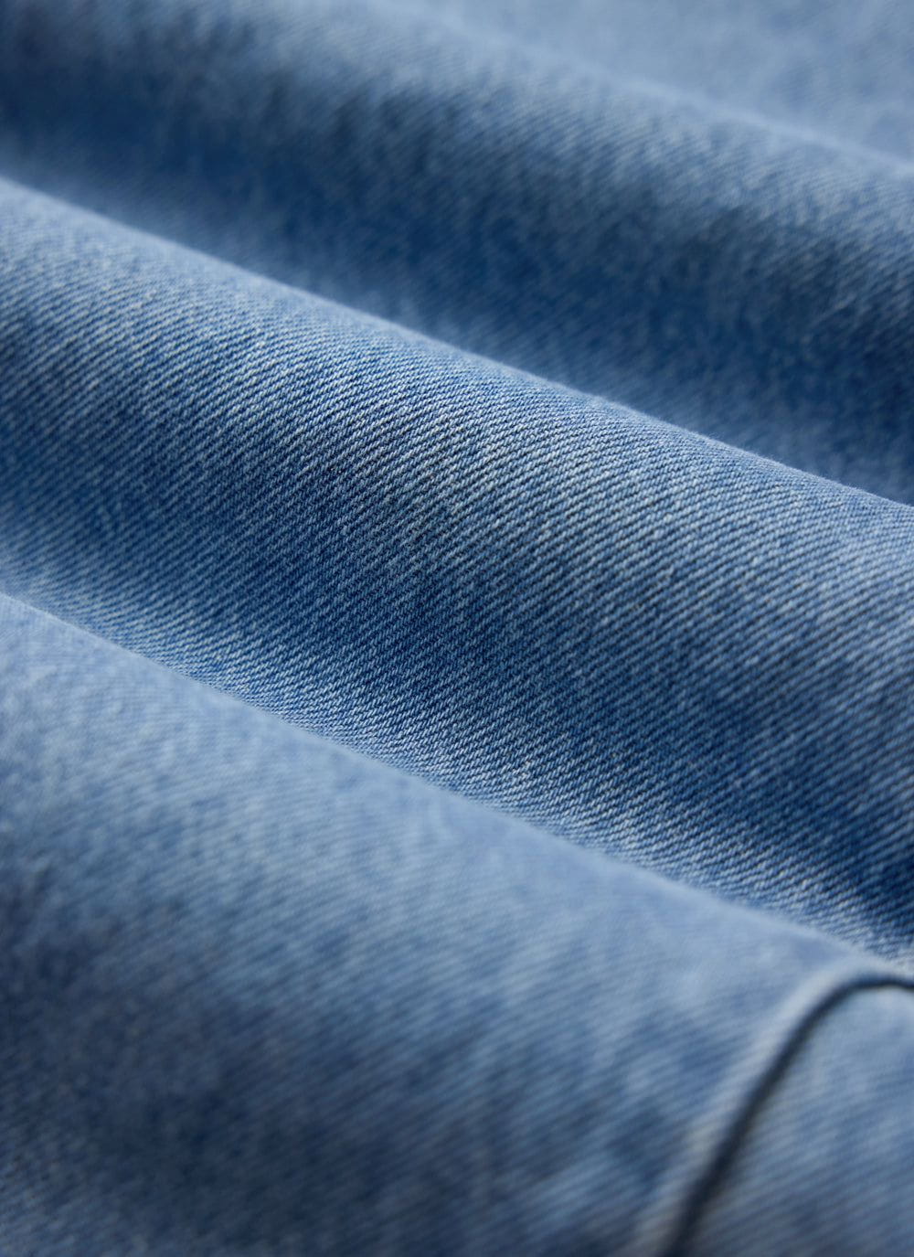 A close-up of the light wash blue denim fabric on the Percival Straight Leg Jeans.
