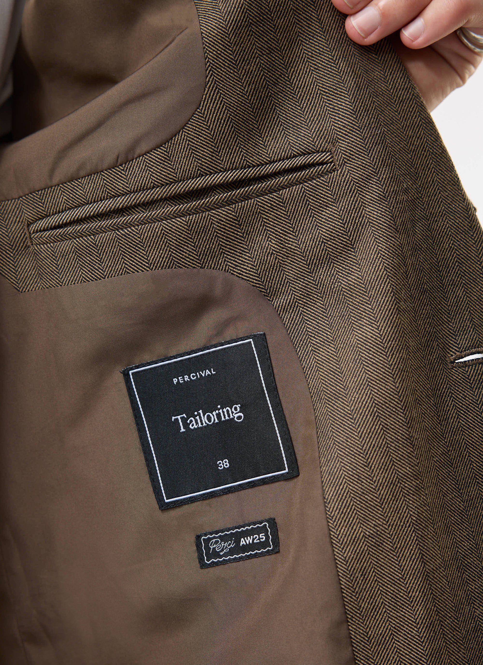 Close-up of the interior of the Percival Grounds Blazer in Oak herringbone, showing the lining, internal pocket and labels.