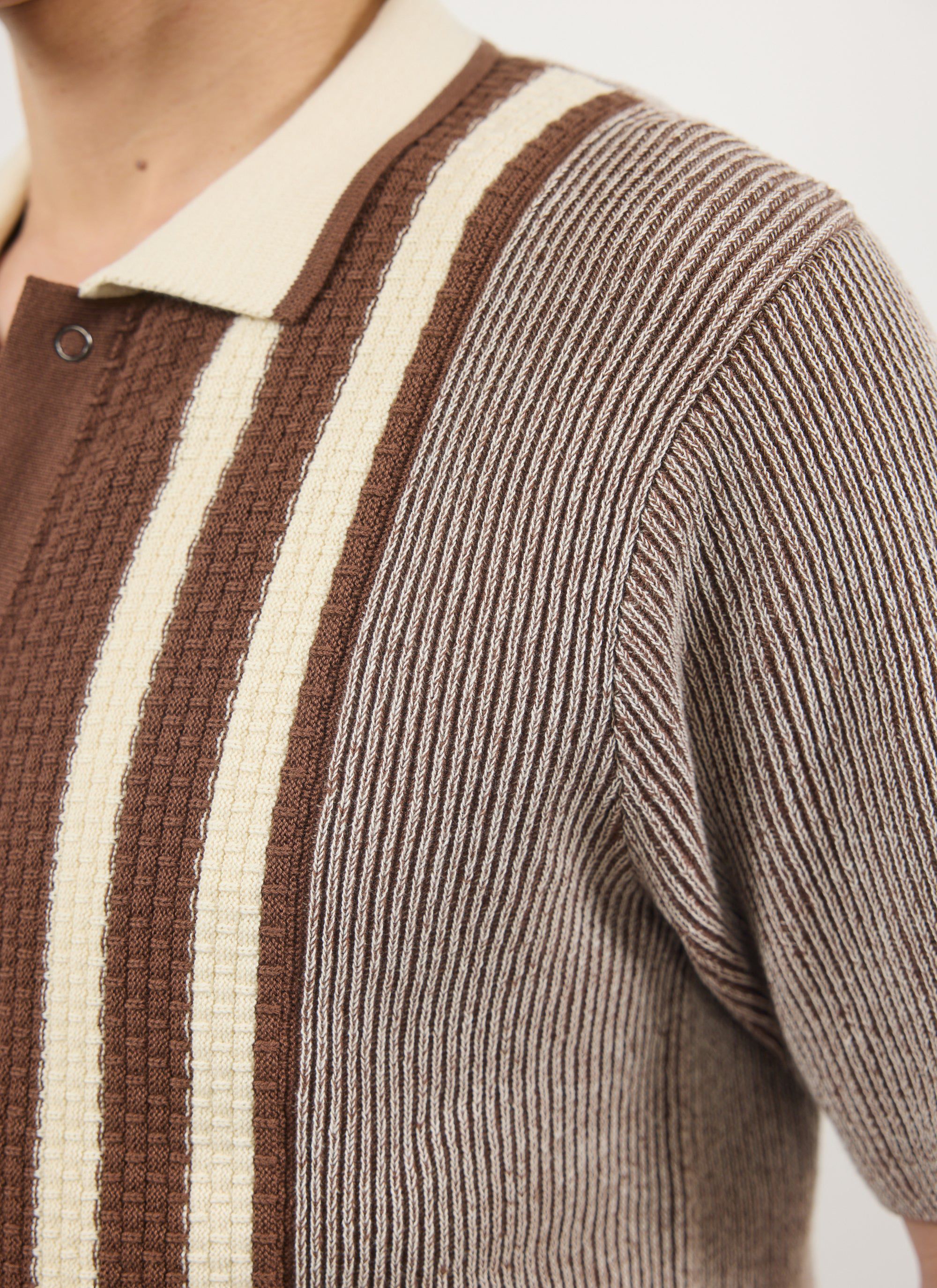 A close-up of the intricate knit details on the shoulder of the Percival Teramo Knitted Polo Shirt in ecru and brown.