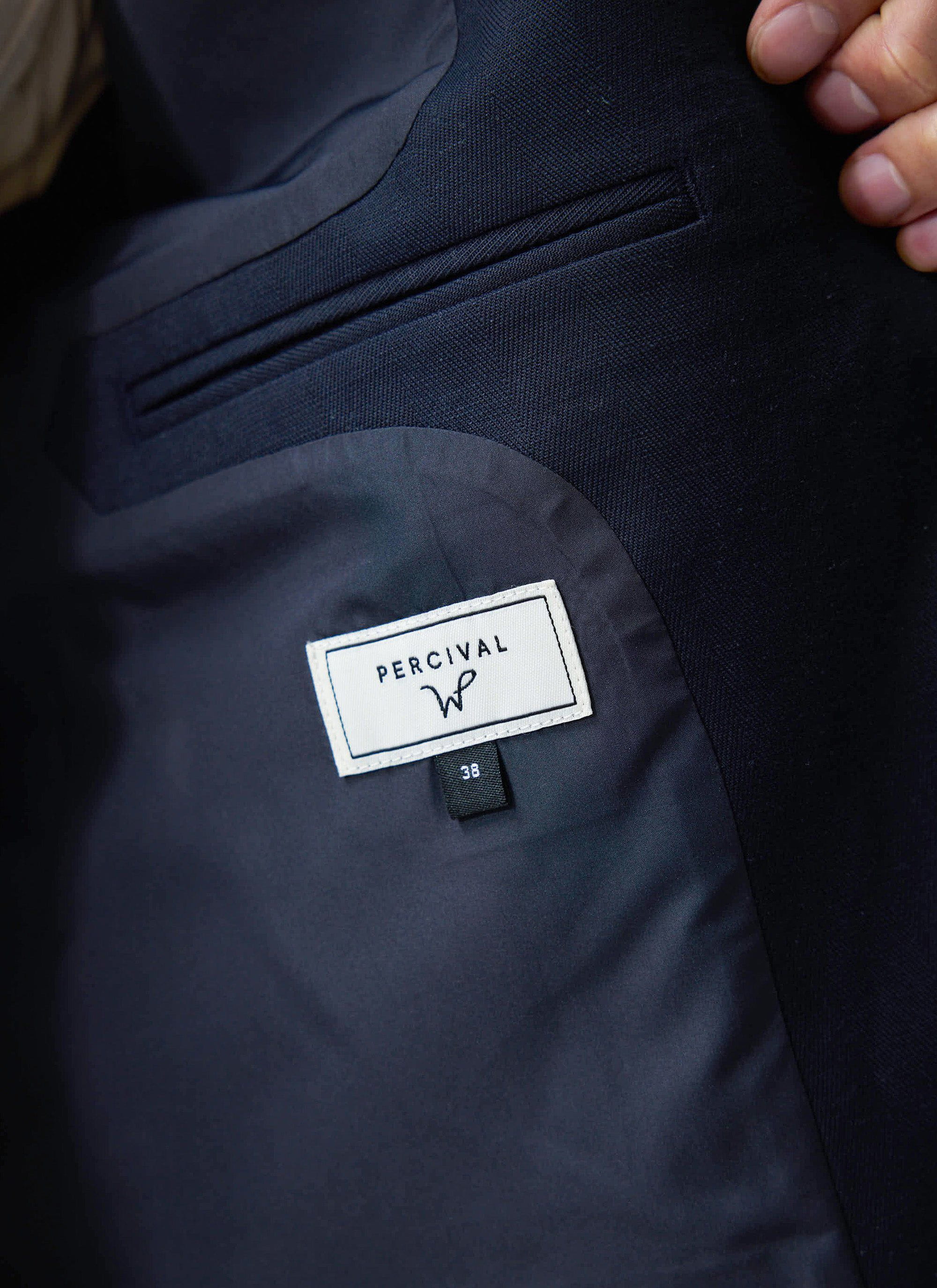 A close-up of the inside pocket and branded label of the navy Lyocell Tailored Blazer, the Percival x Warren collaboration.