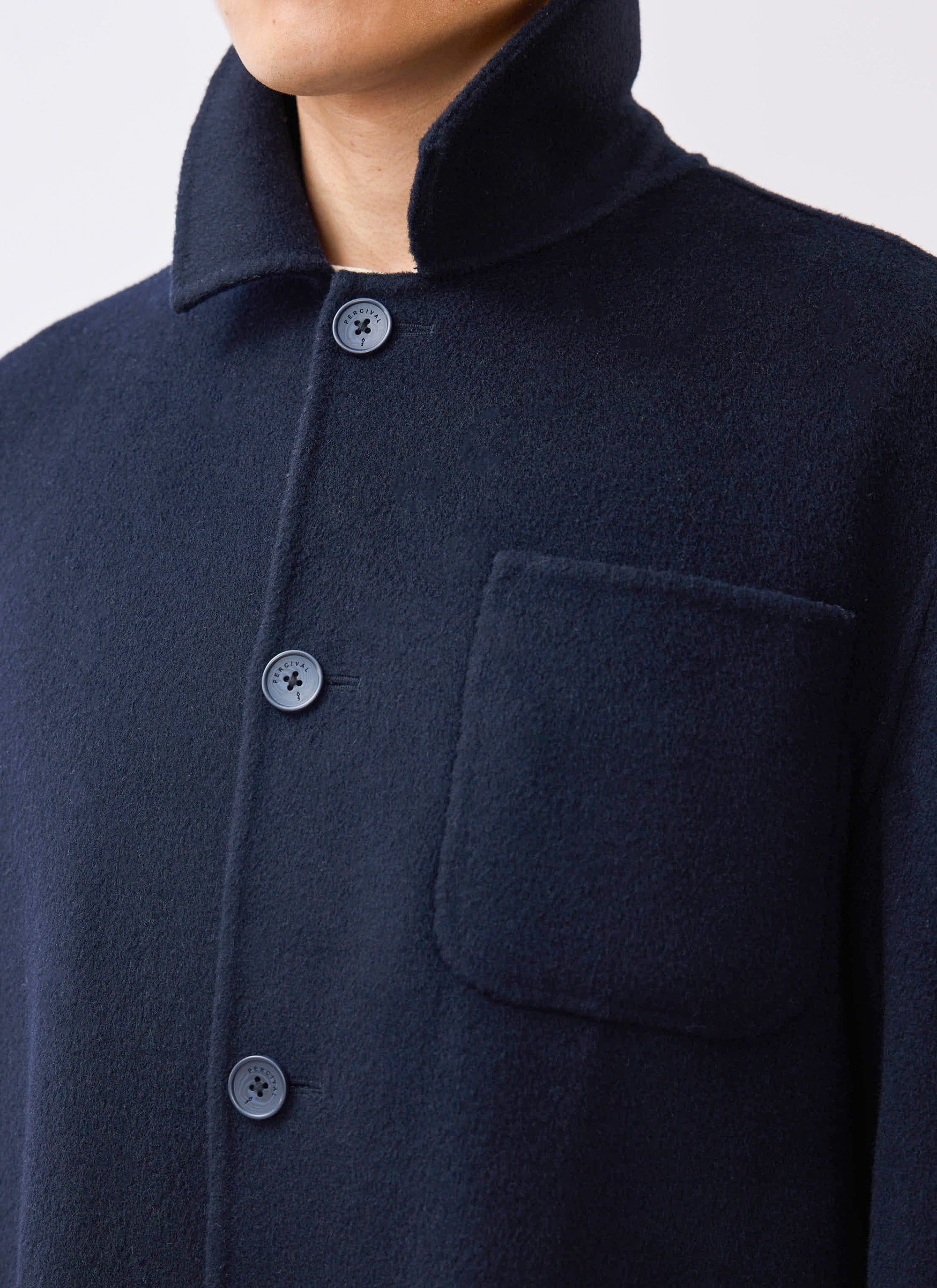 A close-up of the Percival Heavy Wool Overshirt in navy, showing the wool texture, patch pocket and branded buttons.