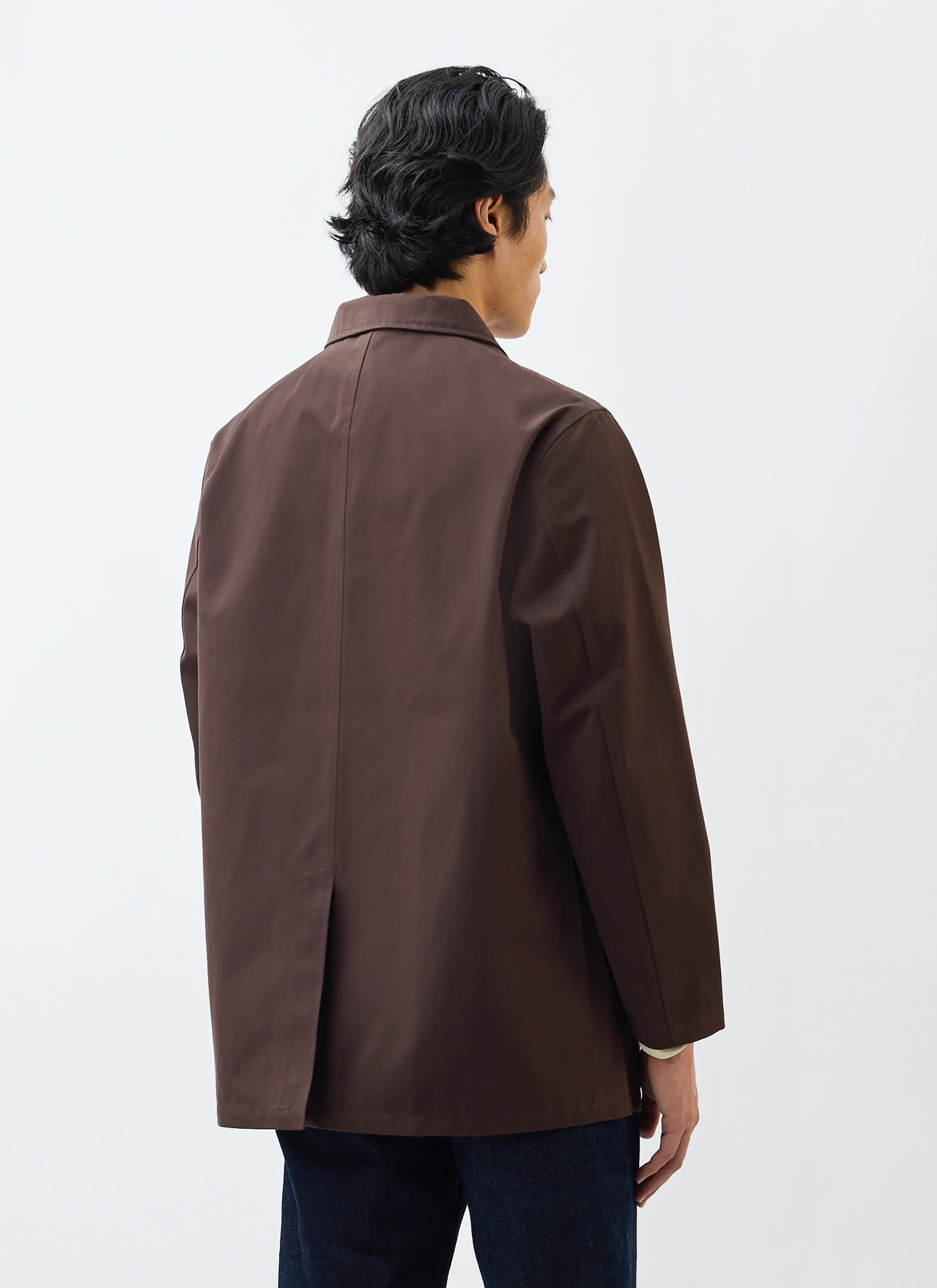 A model wears the Percival Sherlock Short Trench Coat in Espresso, shot from behind to show the fit and single back vent.