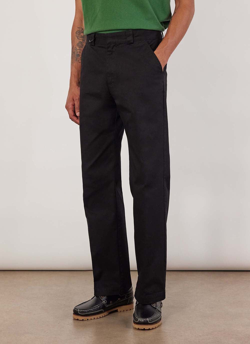 A model wears the Percival Stay Press Trousers in black. They are a straight leg fit made from a cotton twill canvas.