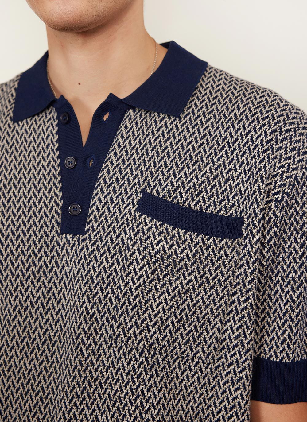 Close up of the Percival Casa Martini Knitted Polo in navy, showing the geometric knit pattern, solid collar & chest pocket.