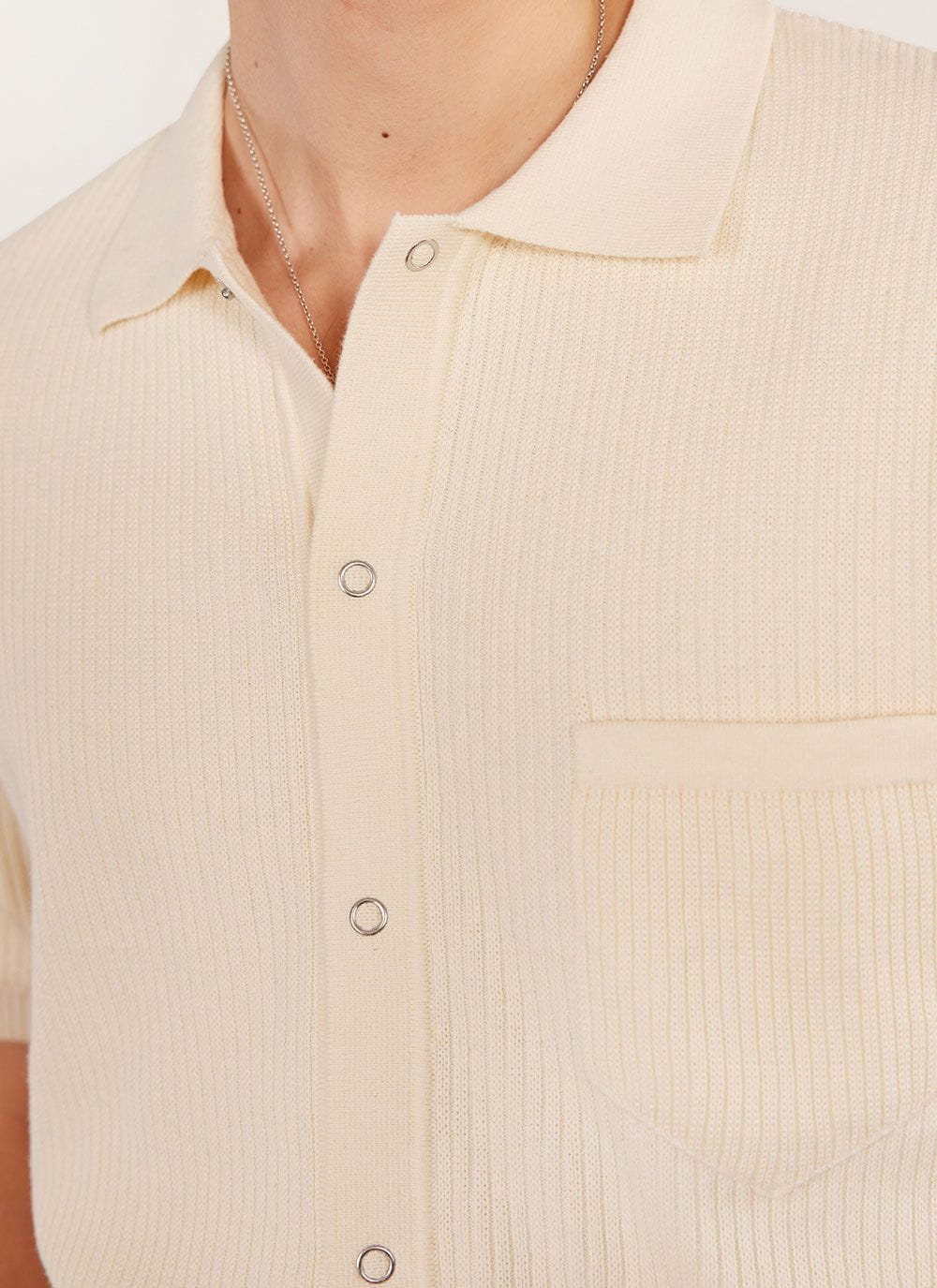 Close up of the Percival Pablo Cuban shirt in cream, showing the knitted texture, popper buttons and chest pocket.