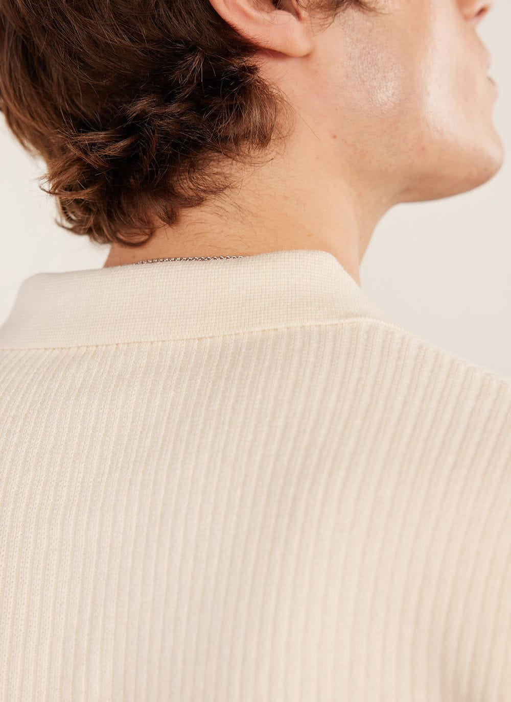 Close up of the collar and back of the cream Percival Pablo Cuban knitted shirt worn by a model.