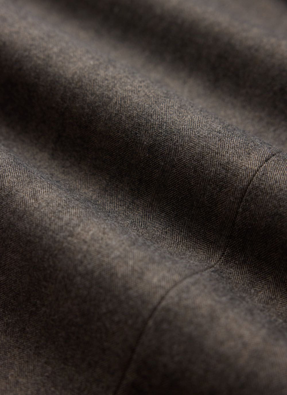 A close-up of the grey herringbone fabric and seam detail on a Percival double breasted blazer.