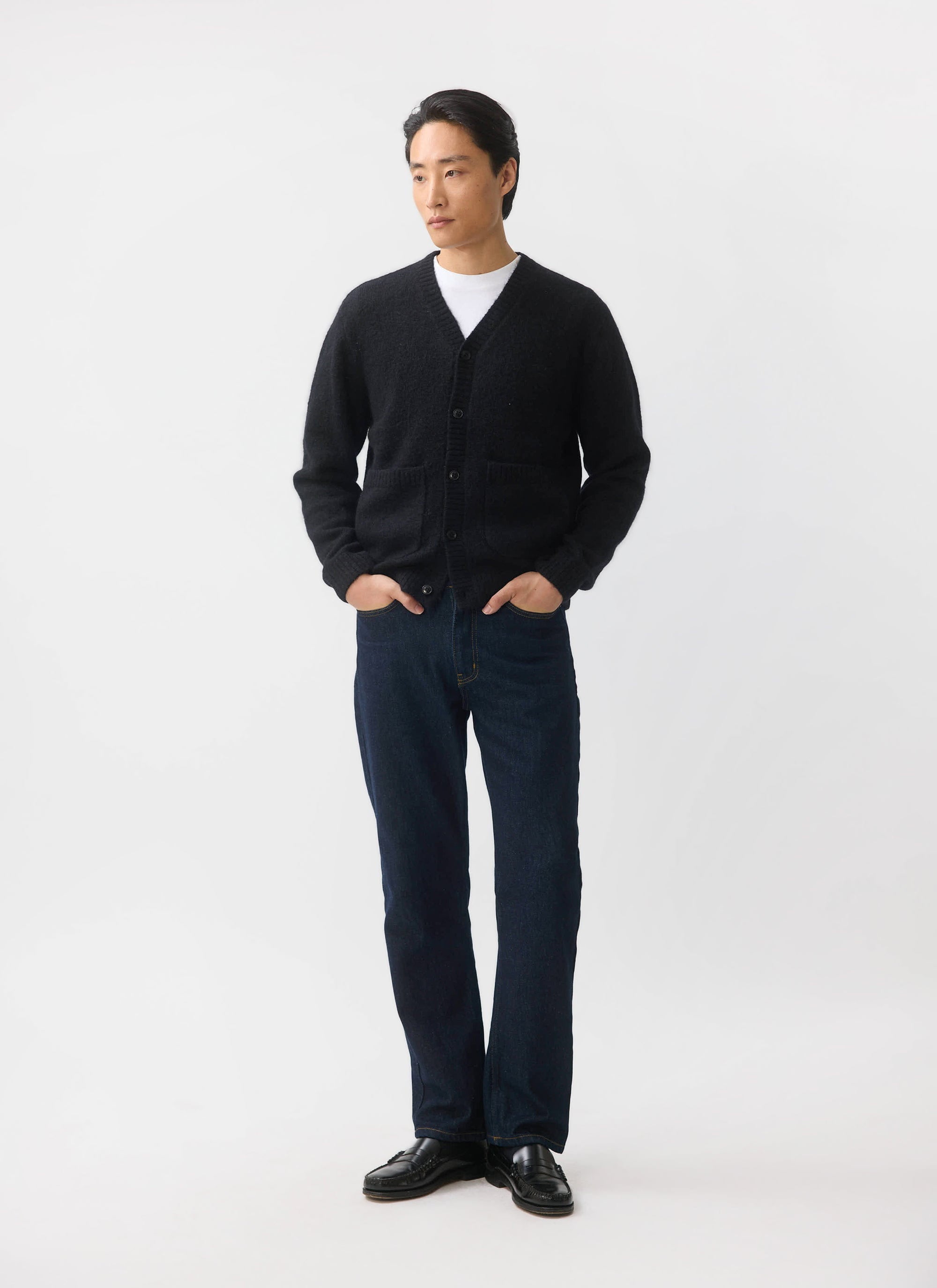 A man models the black mohair White Glove Cardigan from Percival, styled with dark jeans against a white background.