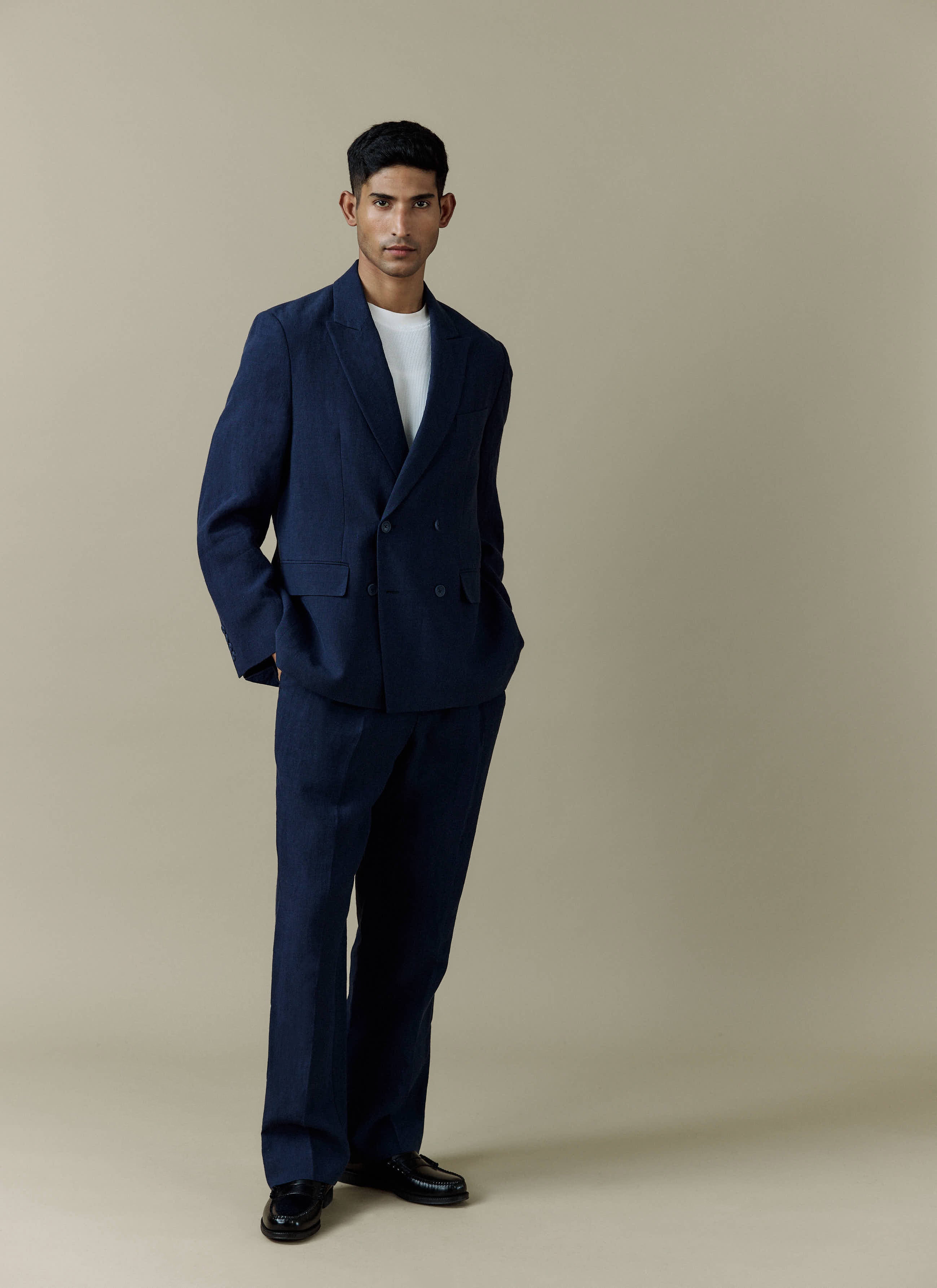 A model wears the Percival Clifton Double Breasted Blazer in navy linen, styled with matching trousers and a white t-shirt.