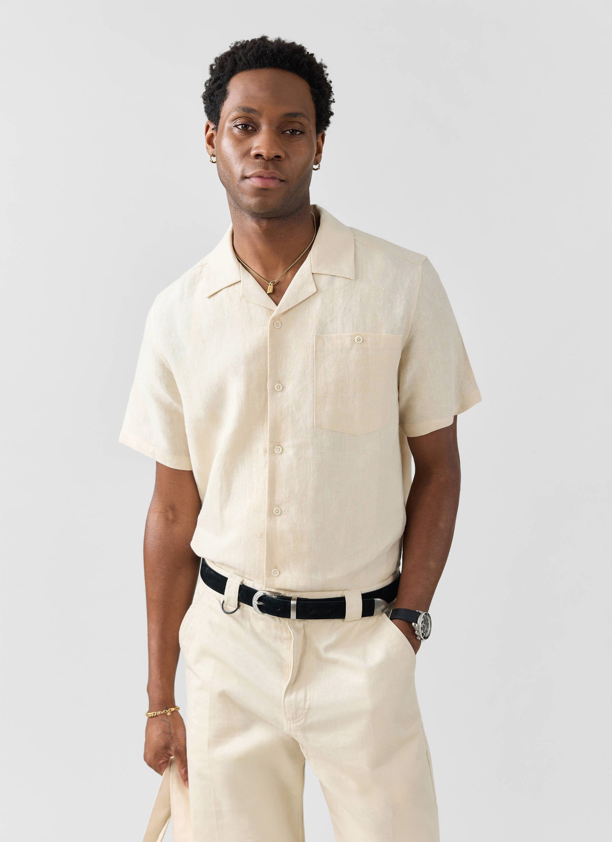 A model wears the Percival cream linen short sleeve Cuban shirt with matching trousers against a white background.