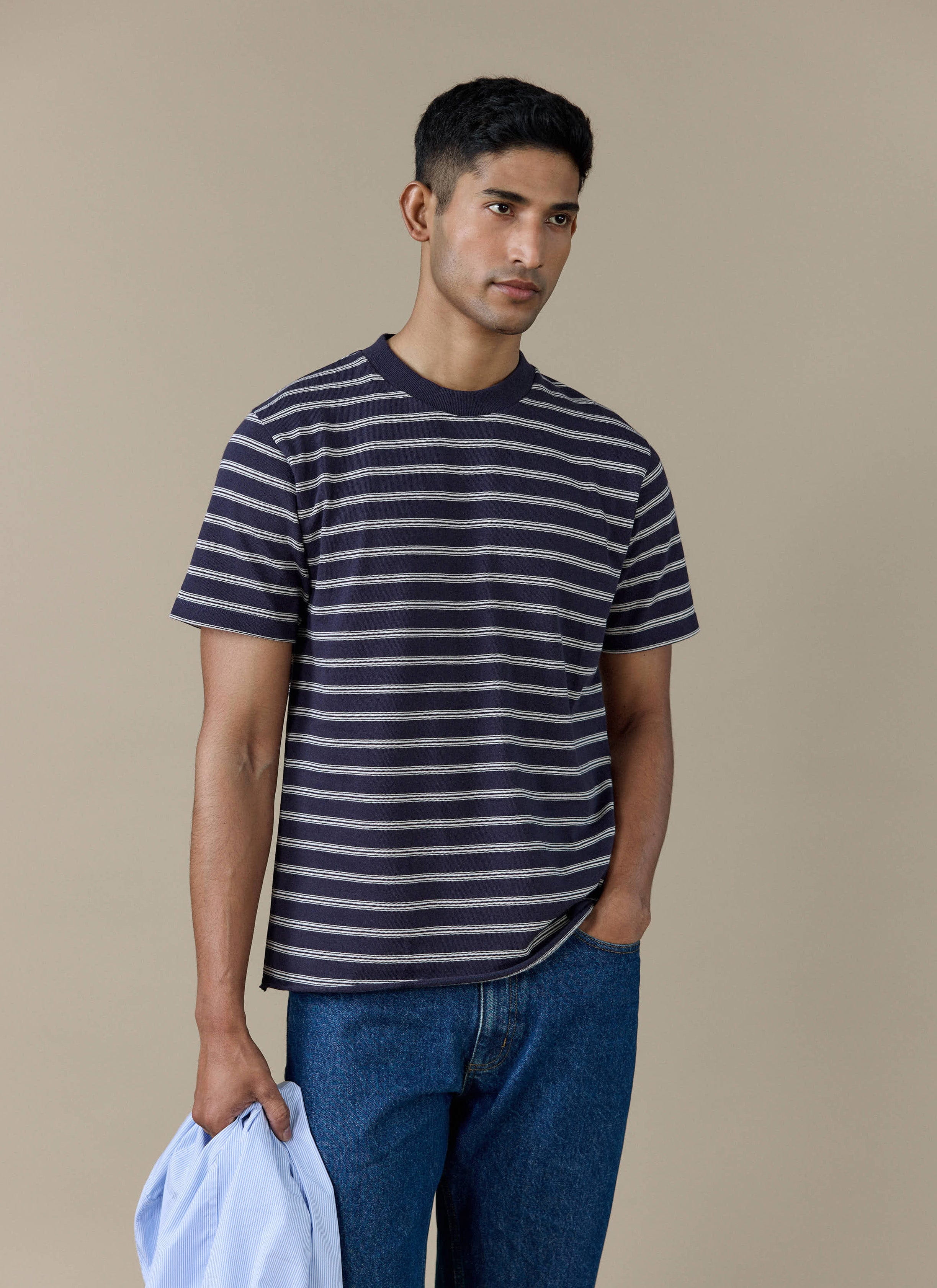 Model wearing the navy stripe Arlo Raw Hem Breton T-Shirt from Percival, styled with denim jeans.