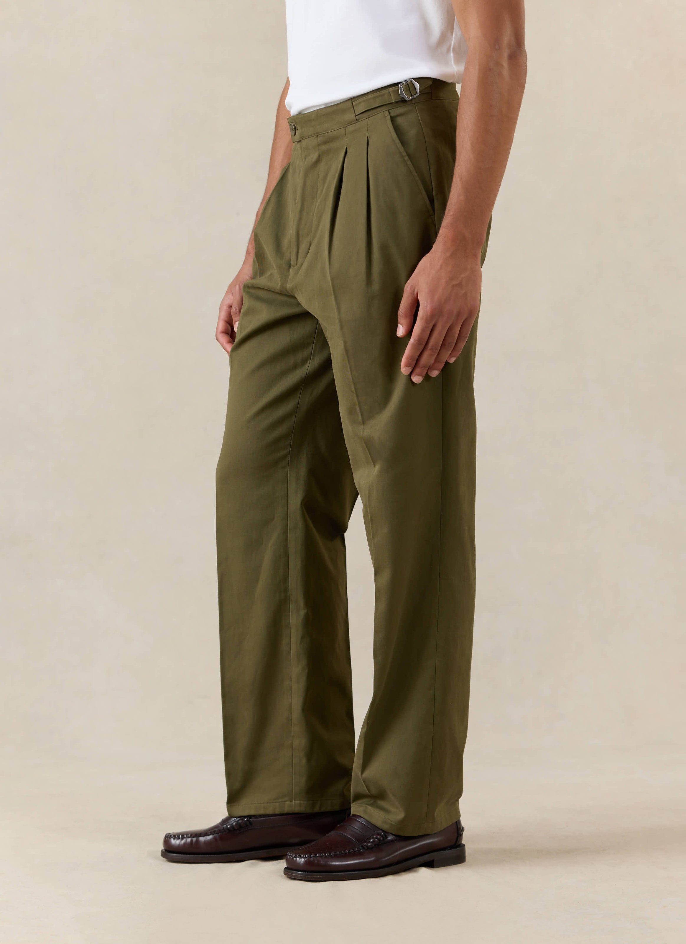 Percival Blake Double Pleated Tailored Trousers in Forest green moleskin, worn with a white tee and brown loafers.