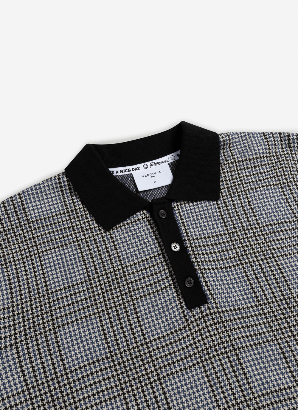 Close-up of the Percival Casa Martini Knitted Polo in navy, highlighting the cotton puppytooth pattern and black collar.