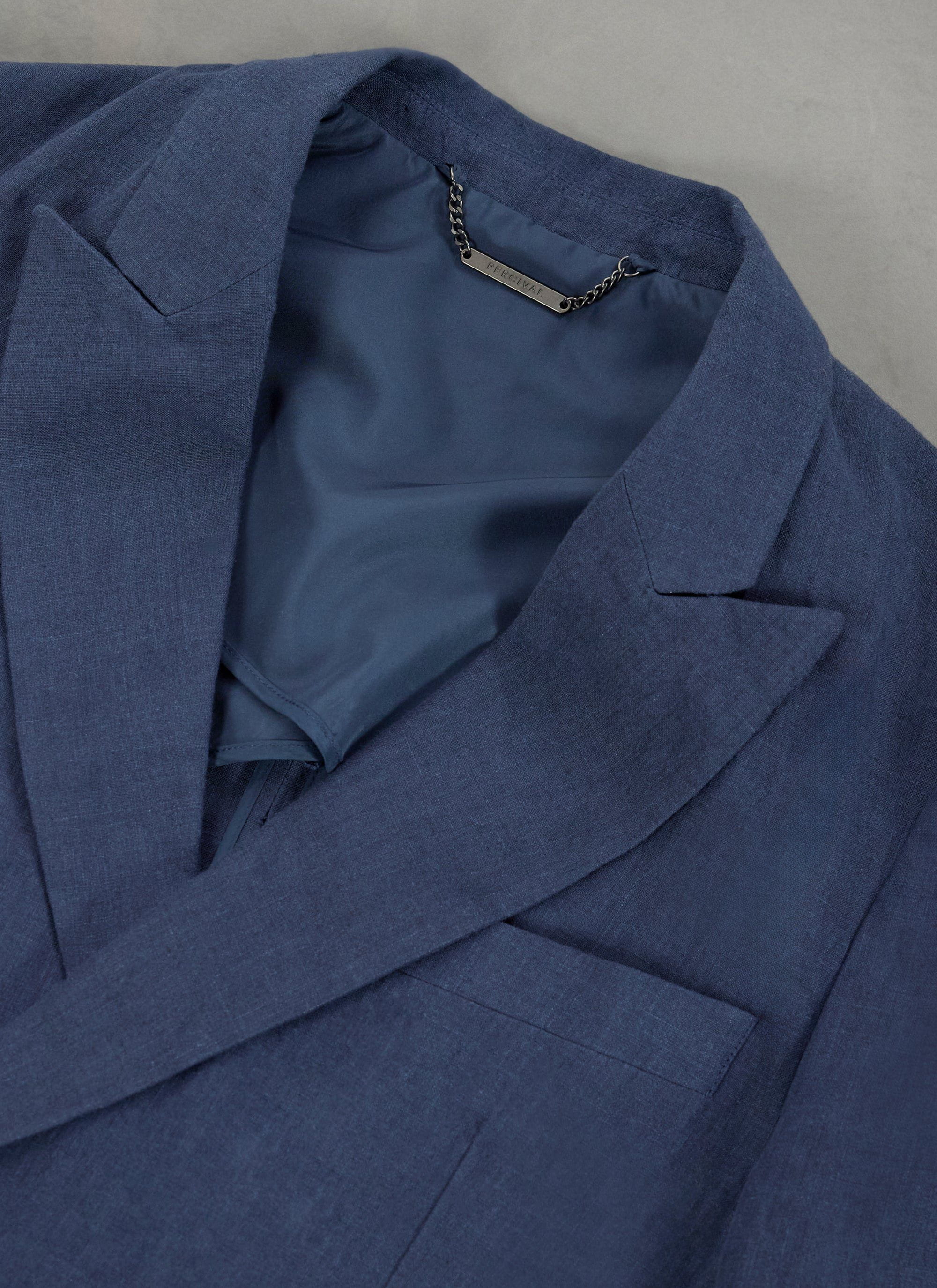 Close up of the Percival navy linen double breasted blazer's collar, lapel and inner branded chain.