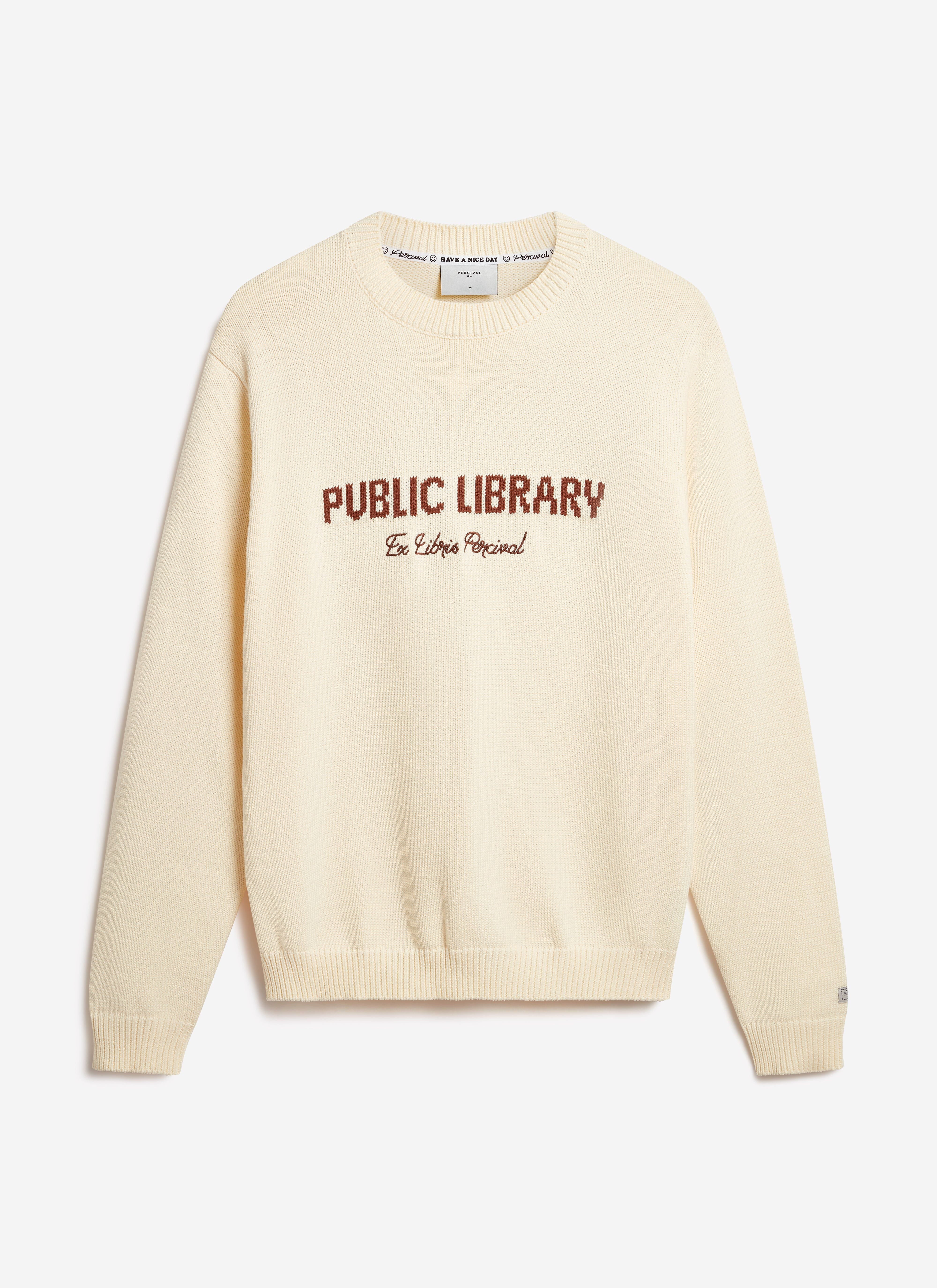 The Percival Public Library wool-blend jumper in ecru, laid flat to showcase its 'Ex Libris Percival' chest embroidery.