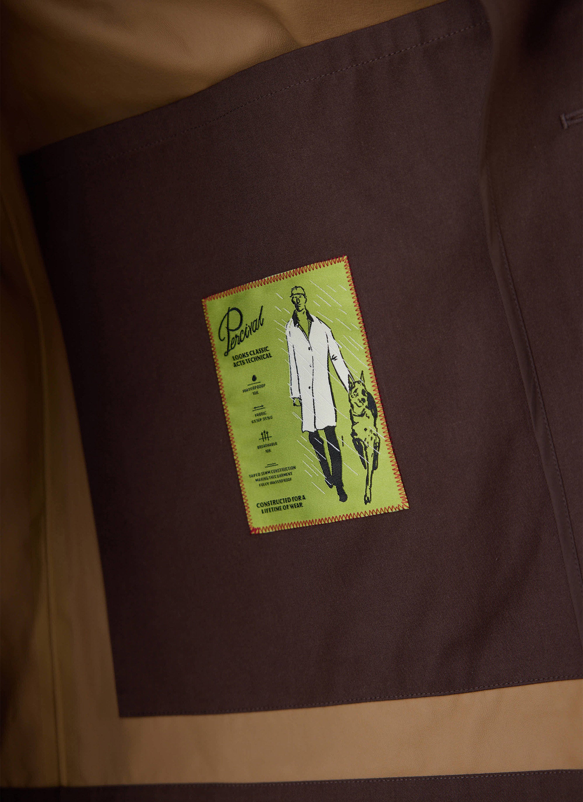 Close-up of internal pocket graphic inside the espresso brown Percival Sherlock short trench coat, showing technical details.