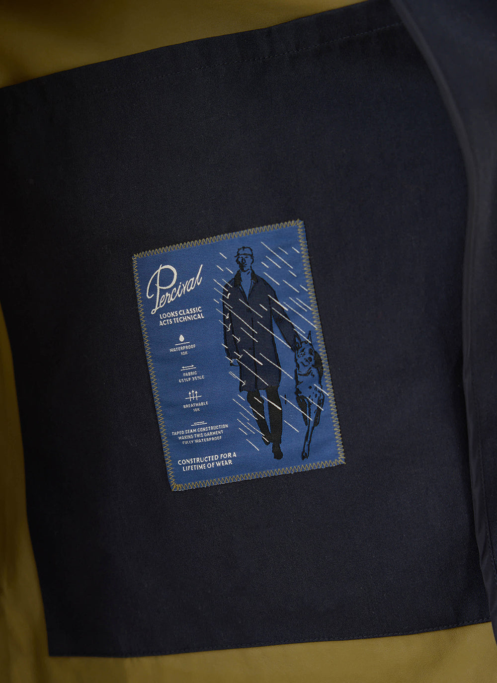 Close-up of the interior label on the Percival navy Sherlock trench coat showing technical details and waterproof specs.