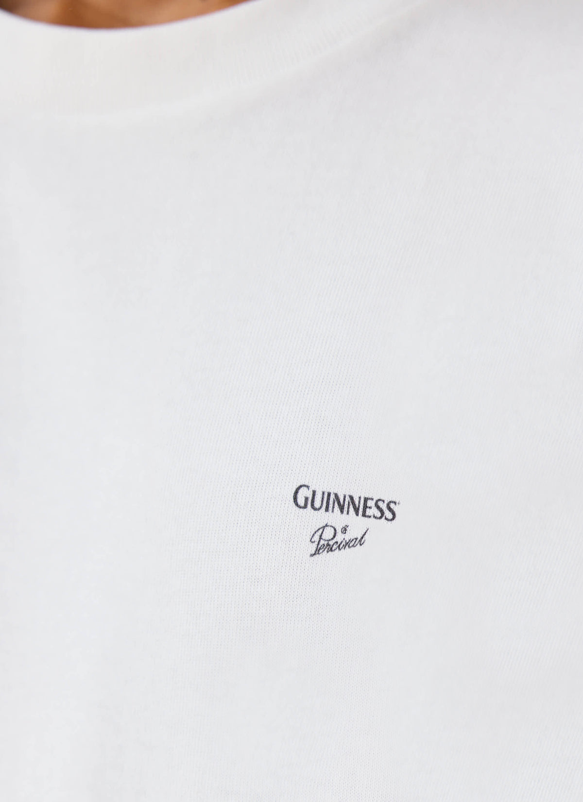 A close-up of the white Guinness x Percival Soloist T-shirt showing the printed chest logo.