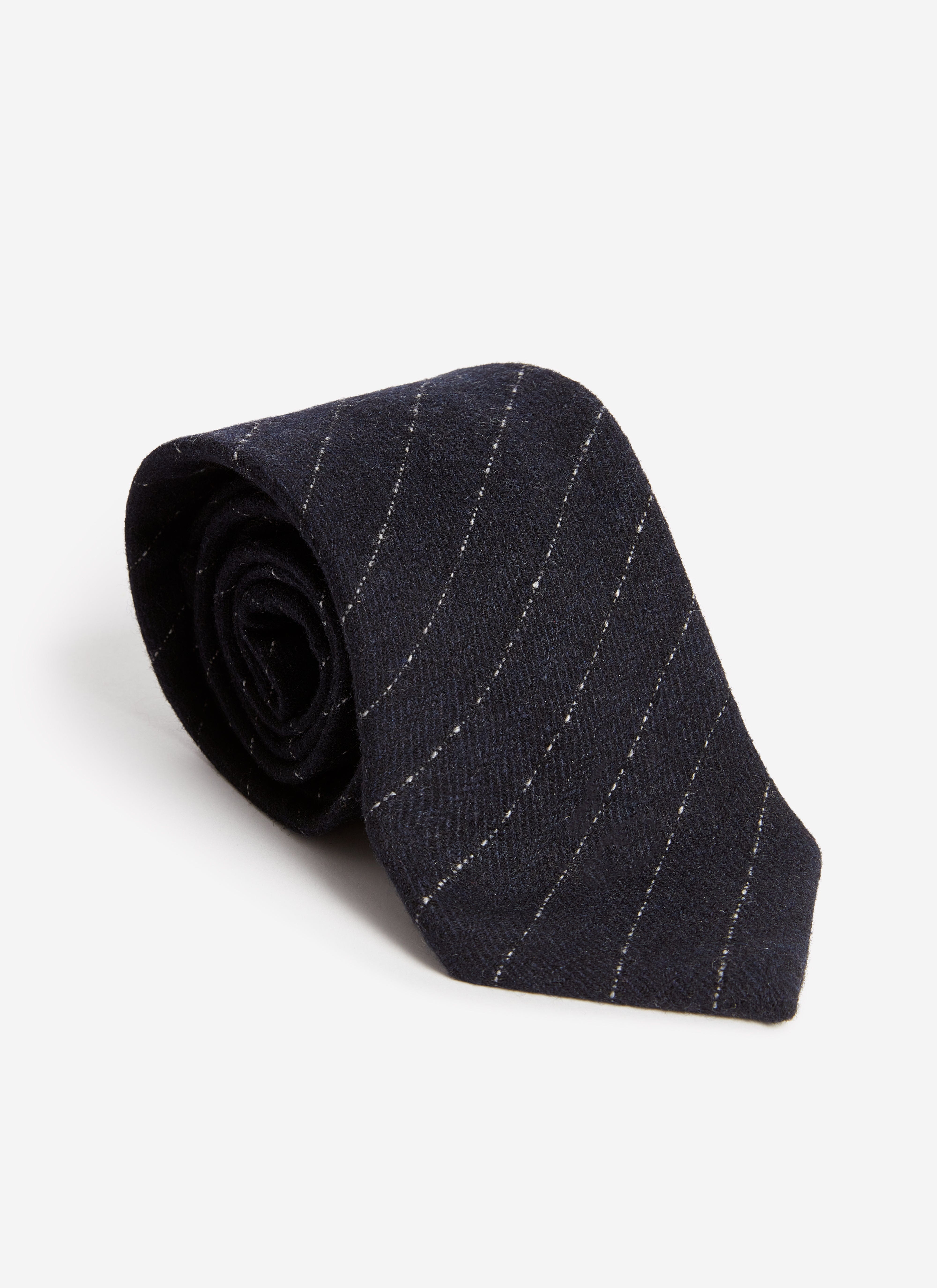 The Percival Textured Stripe Tie in navy, a cotton-blend tie with a diagonal stripe, rolled up on a white background.