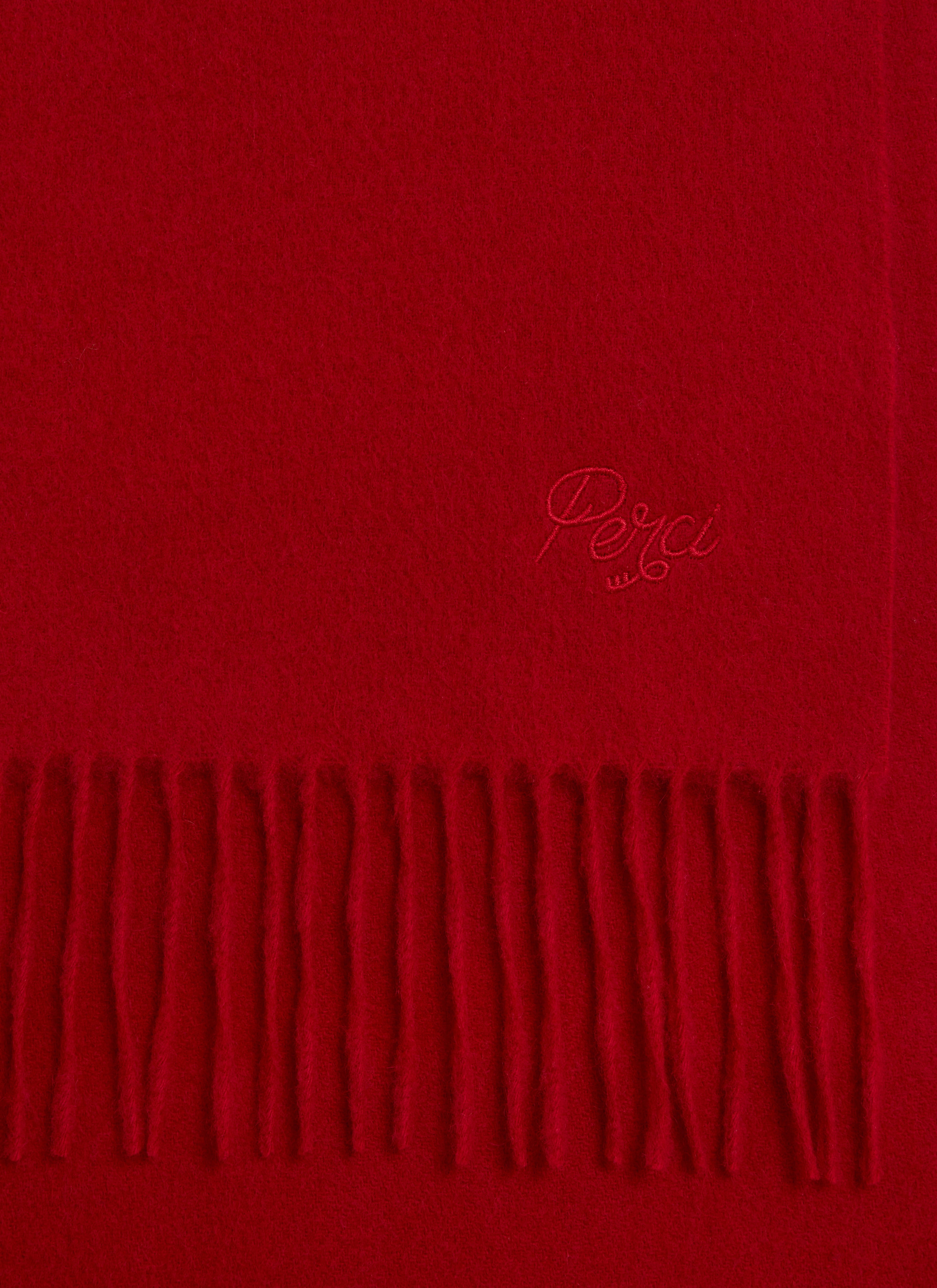 A close-up of the red wool Tolkein Scarf from Percival, showing the tonal embroidery and classic fringed hem.
