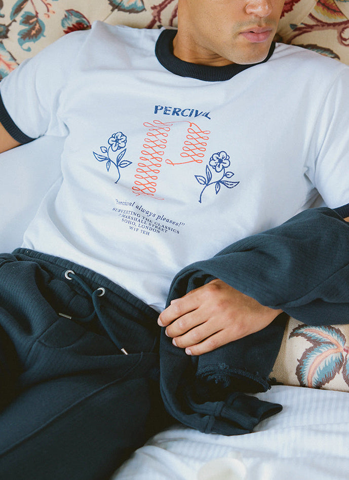 Percival white ringer t-shirt with navy contrast collar and graphic chest print, styled with navy Conrad trackpants.