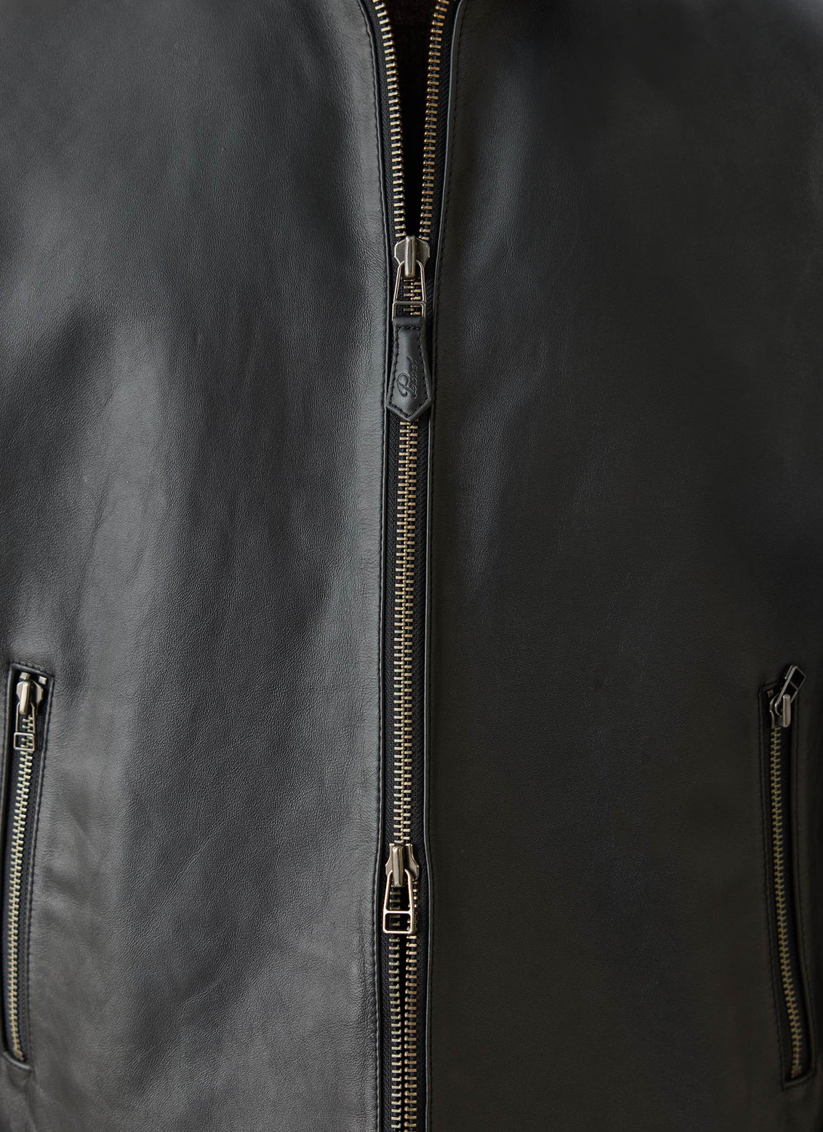 A close-up of the Percival Turner black leather zip jacket showing the front zipper detail and leather texture.