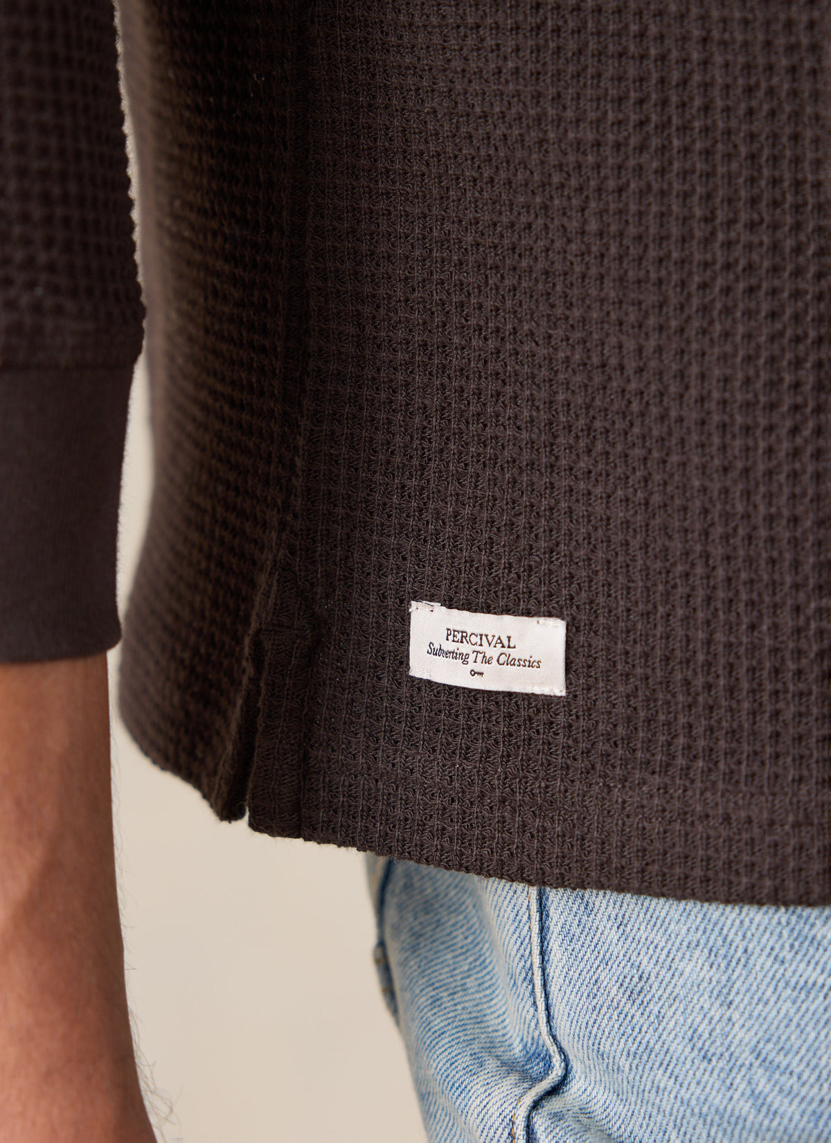 A close-up of the Percival brown waffle long sleeve T-shirt showing the textured cotton fabric and brand tag.