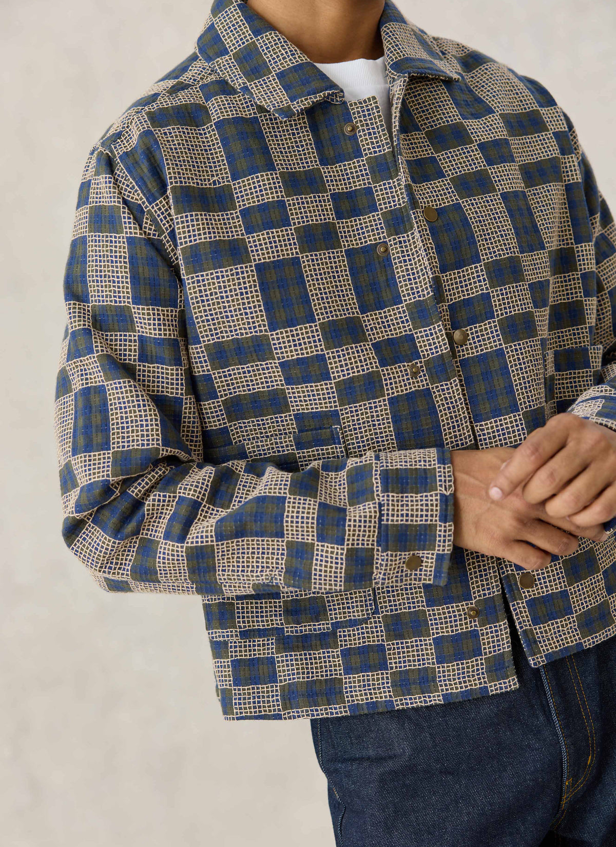 A close-up of the Percival navy blue grid check cotton overshirt showing the textured fabric, button front, and cuffs.