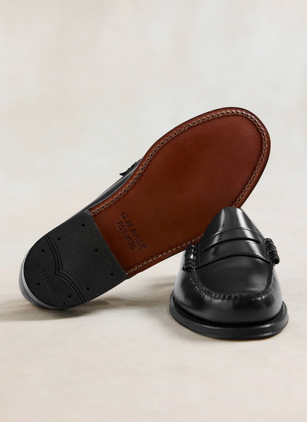 Close-up of G.H. Bass black leather Weejun Larson penny loafers showing the stitched leather sole and rubber heel.