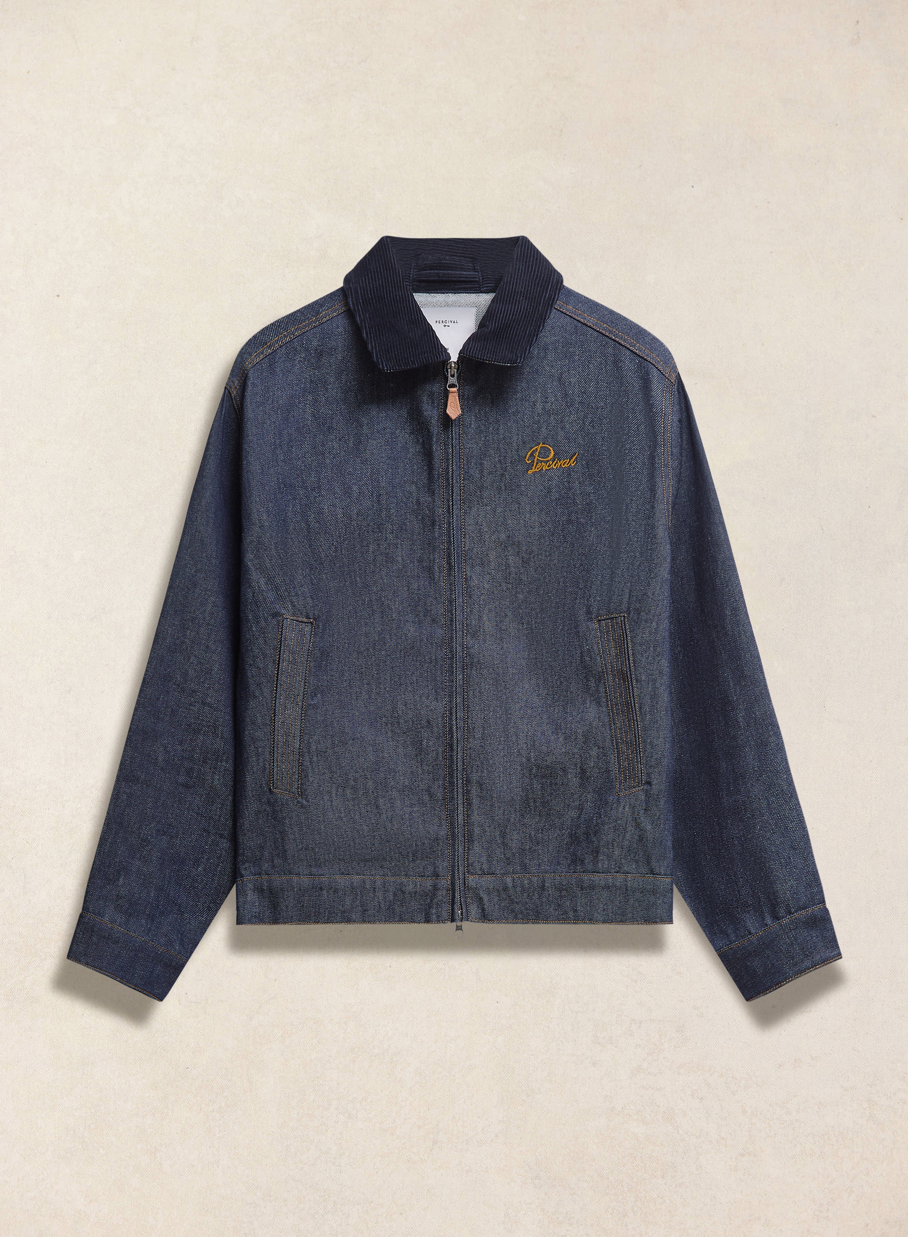 Raw indigo Percival Mackey zip jacket featuring a cord collar and embroidered chest detail.