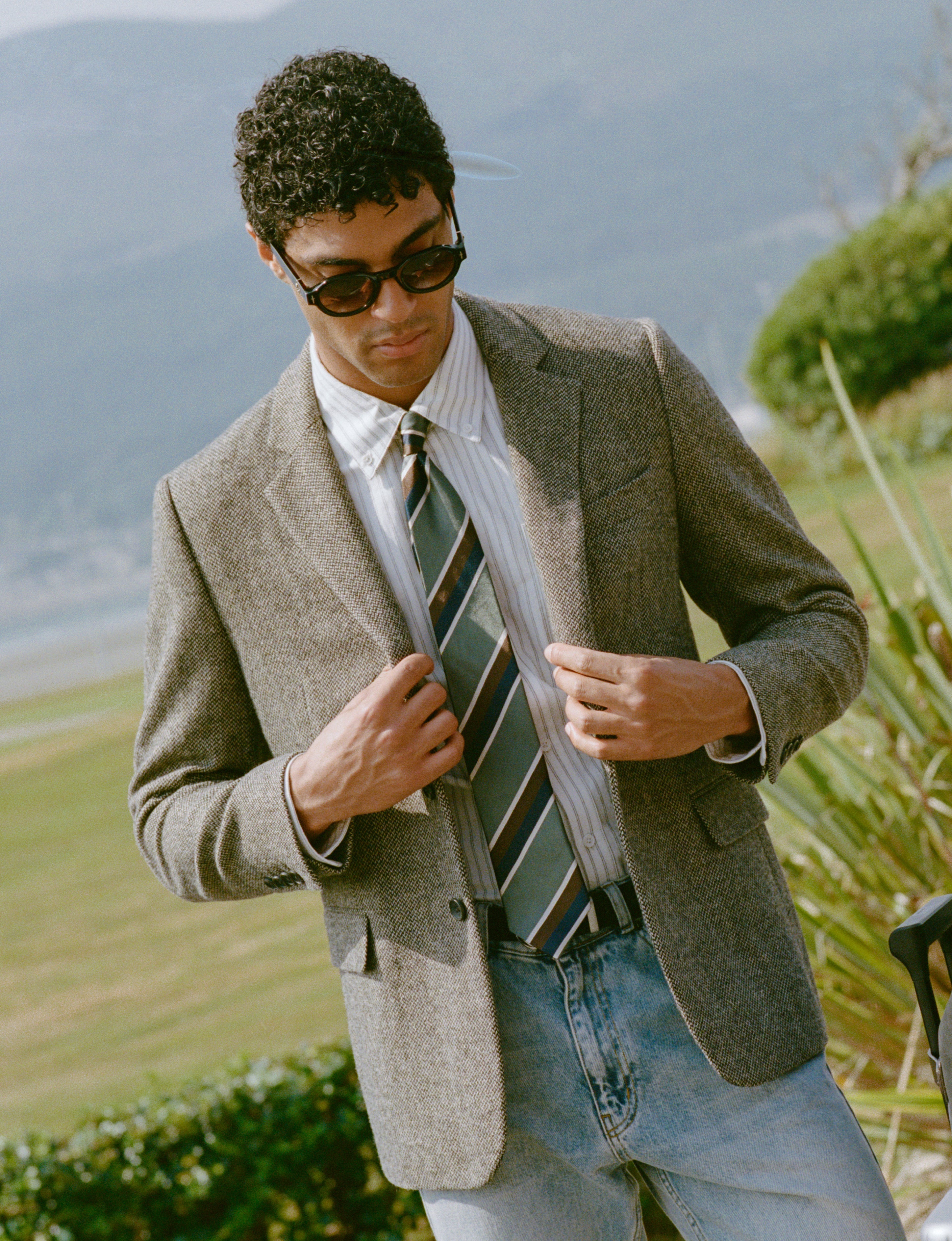 A model wears the Percival Tailored Blazer in Birdseye Wool Grey and the Percival Stripe Tie in Multi Silk.