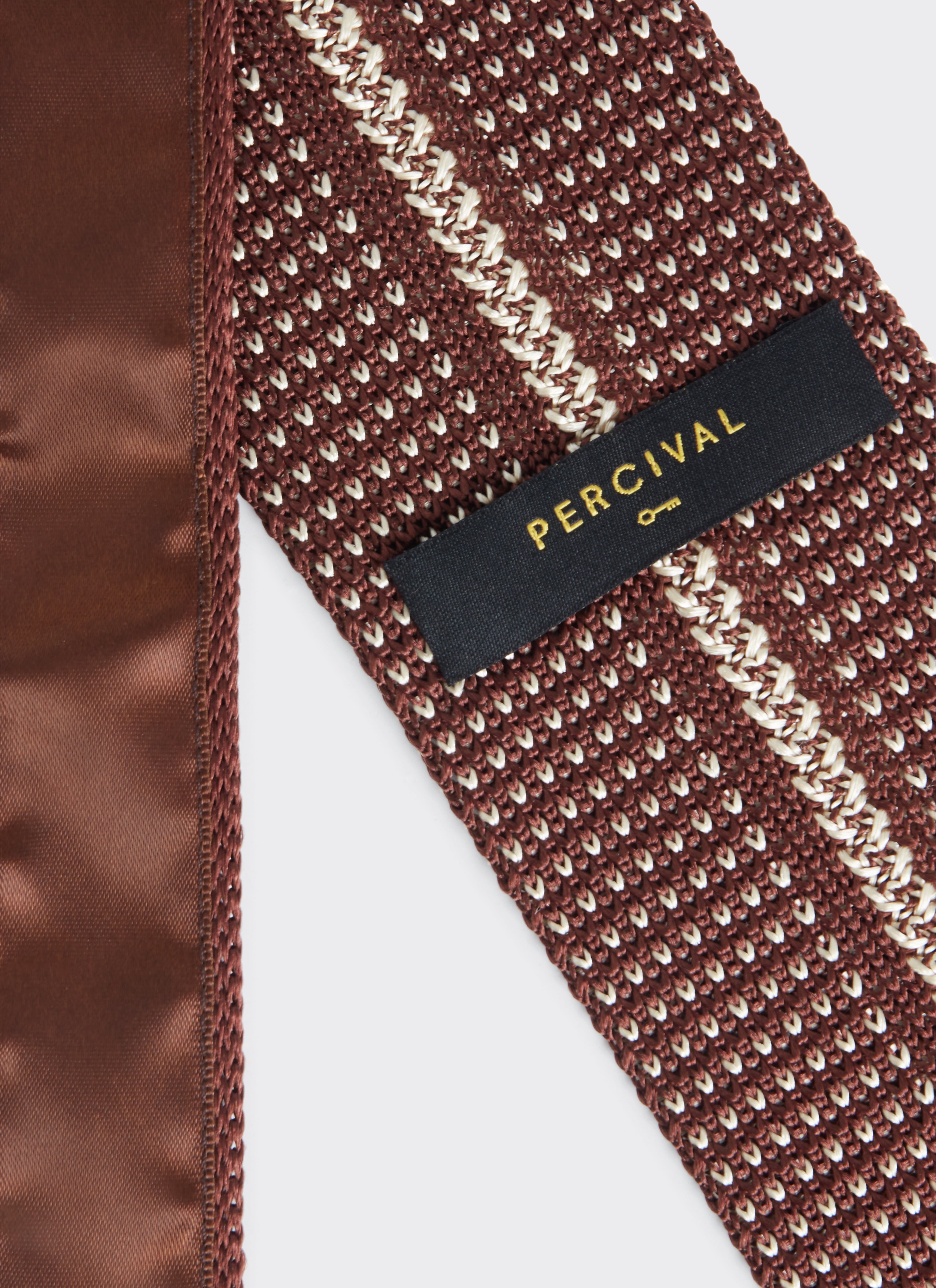 Close-up of the Percival Birdseye Tie in espresso brown silk, showing the textured weave and black brand label.