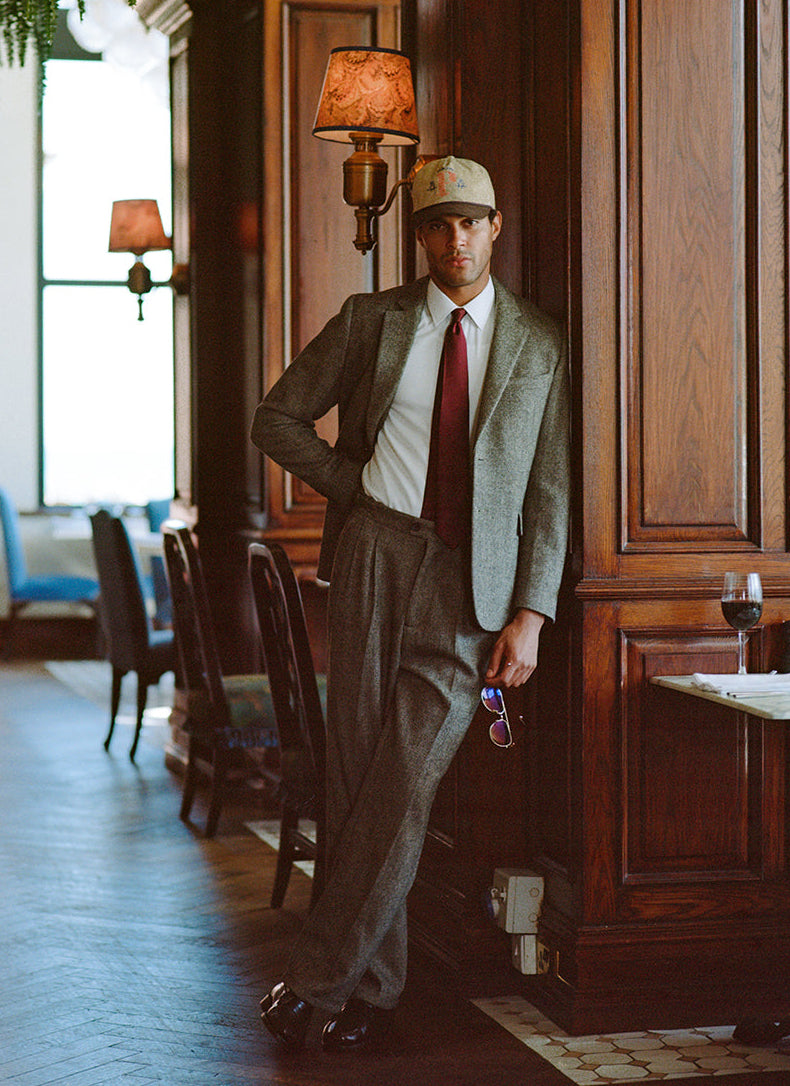 A model wears the Percival Tailored Blazer and Percival Blake Double Pleated Tailored Trousers in grey birdseye wool.