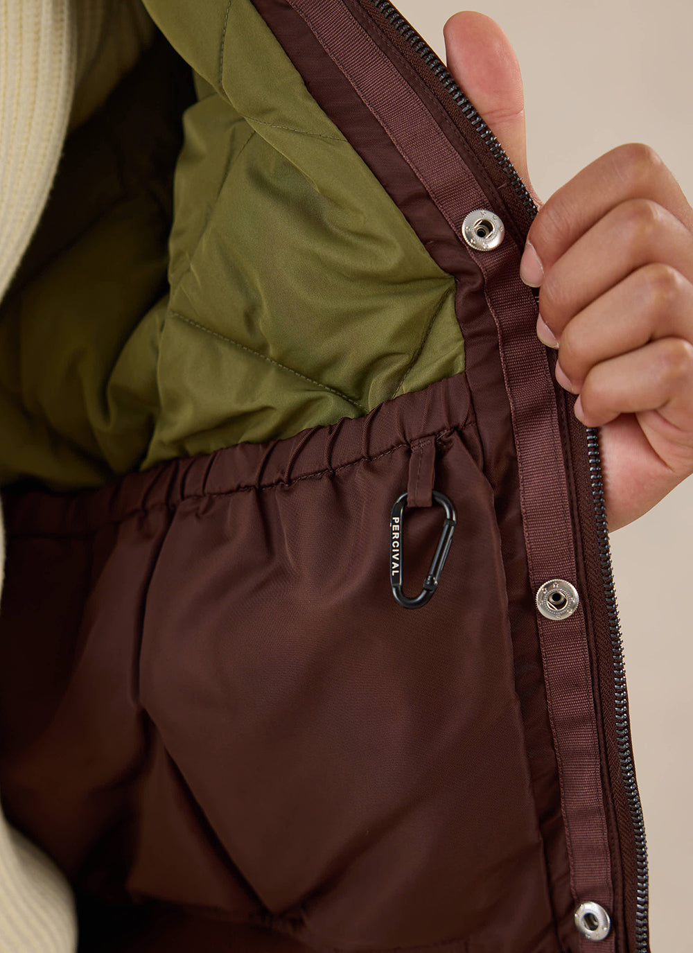 A close-up of the interior pocket and lining of the espresso nylon bomber jacket from Percival.