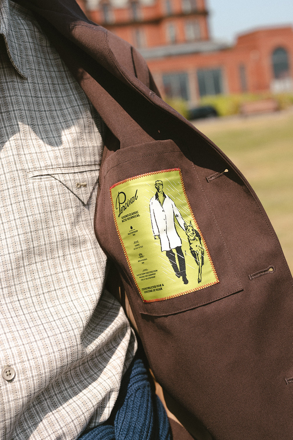 Close-up of the Percival Carter cropped trench coat interior pocket showing the green technical details label.