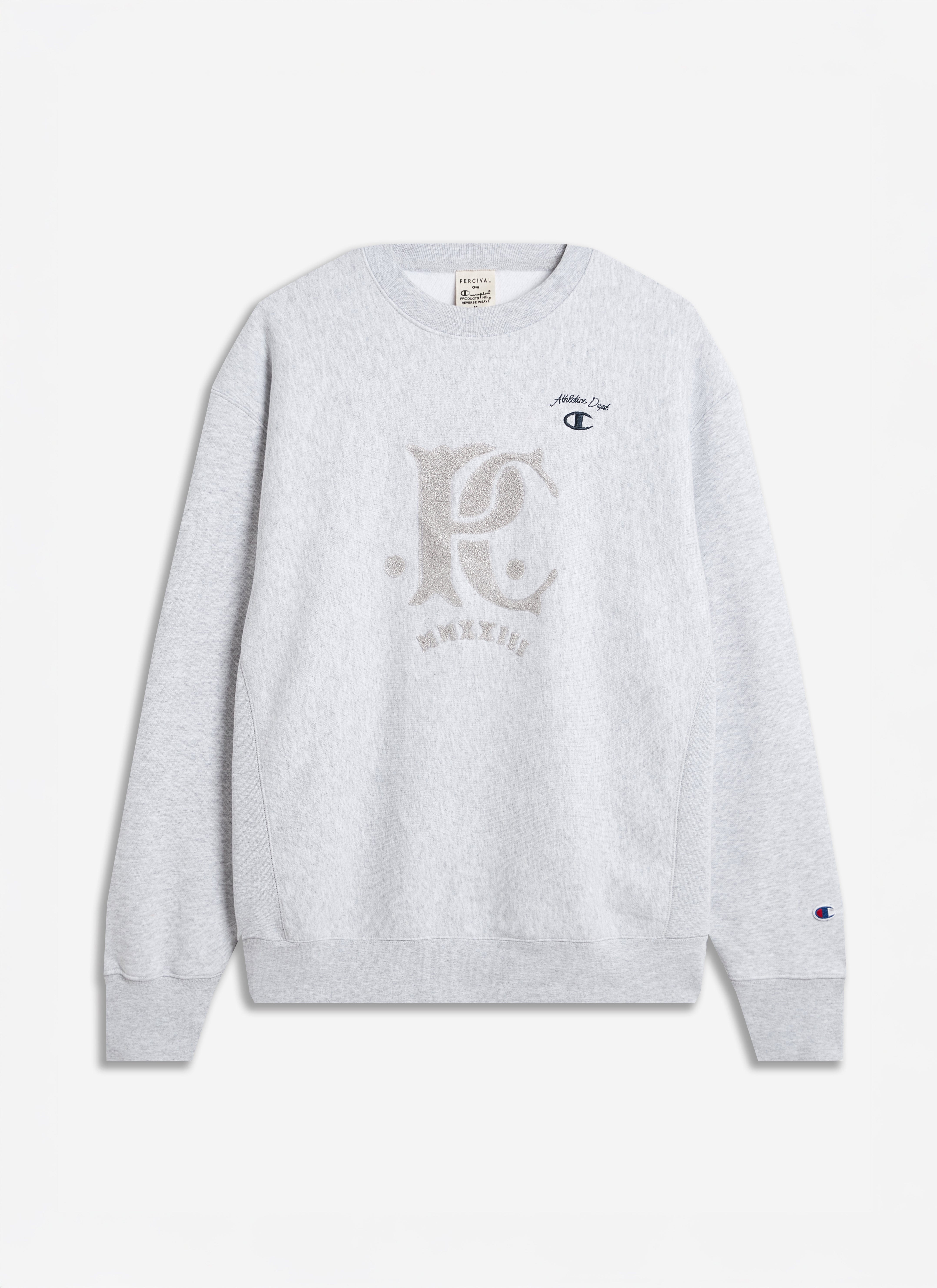 The Champion x Percival grey jersey sweatshirt, laid flat to showcase the tonal chenille patch and relaxed fit.