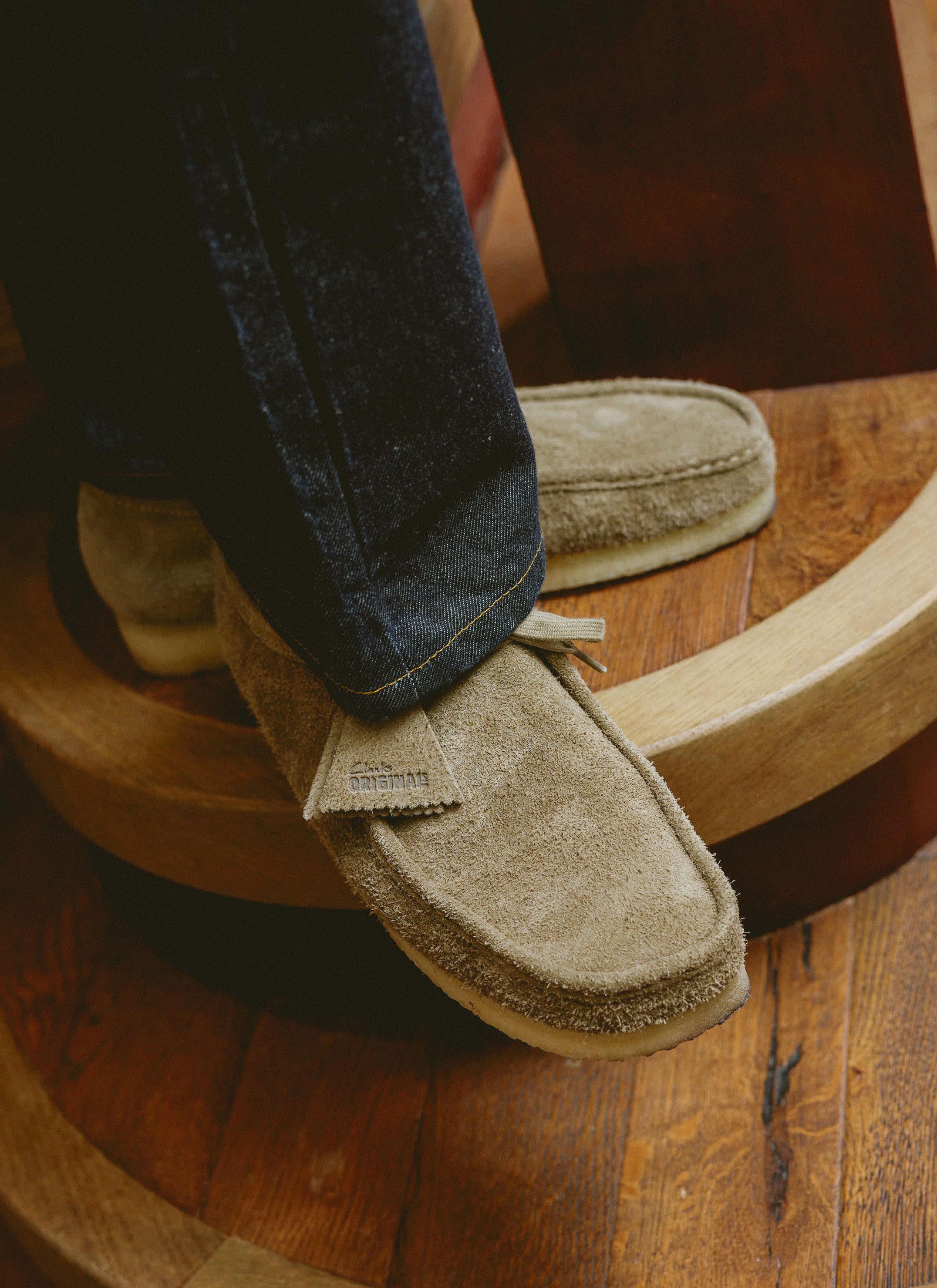 Smoke grey suede Clarks Wallabees with a signature crepe sole, styled with dark denim at Percival.