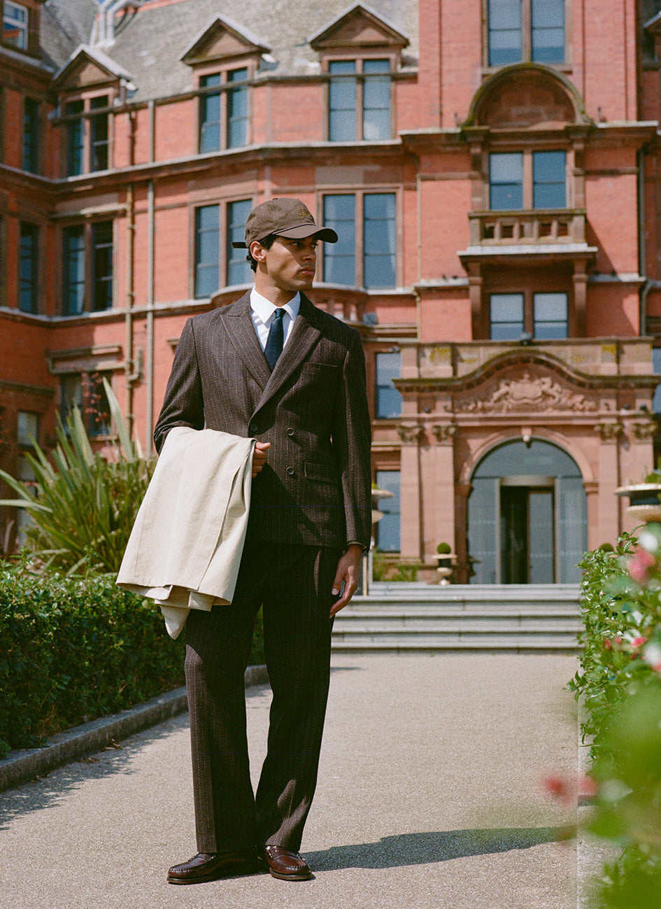 Model wears Percival Clifton Pinstripe Double Breasted Blazer and Clifton Pinstripe Pleated Tailored Trousers in Espresso.