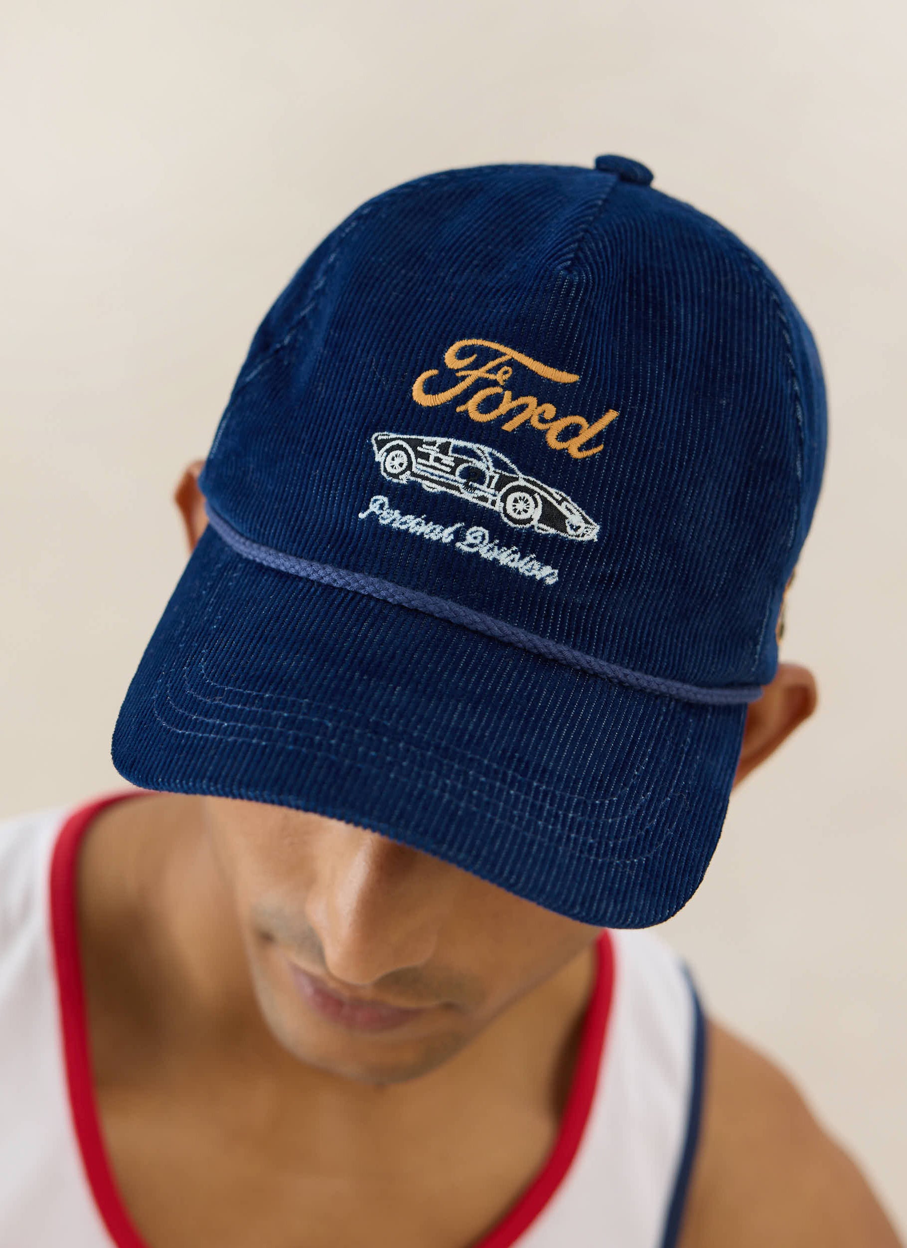 A navy corduroy Ford x Percival trucker cap featuring embroidered motorsport graphics and a contrast rope trim.
