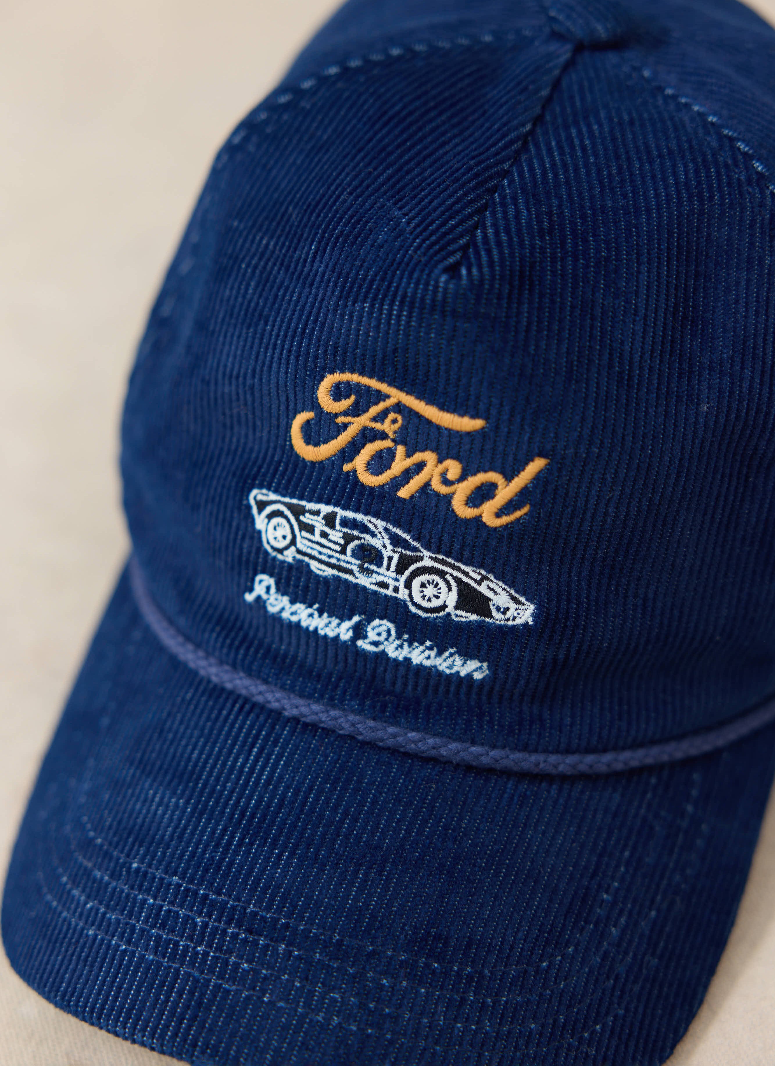 Navy corduroy Ford x Percival trucker cap with yellow car embroidery and white Percival Division text.