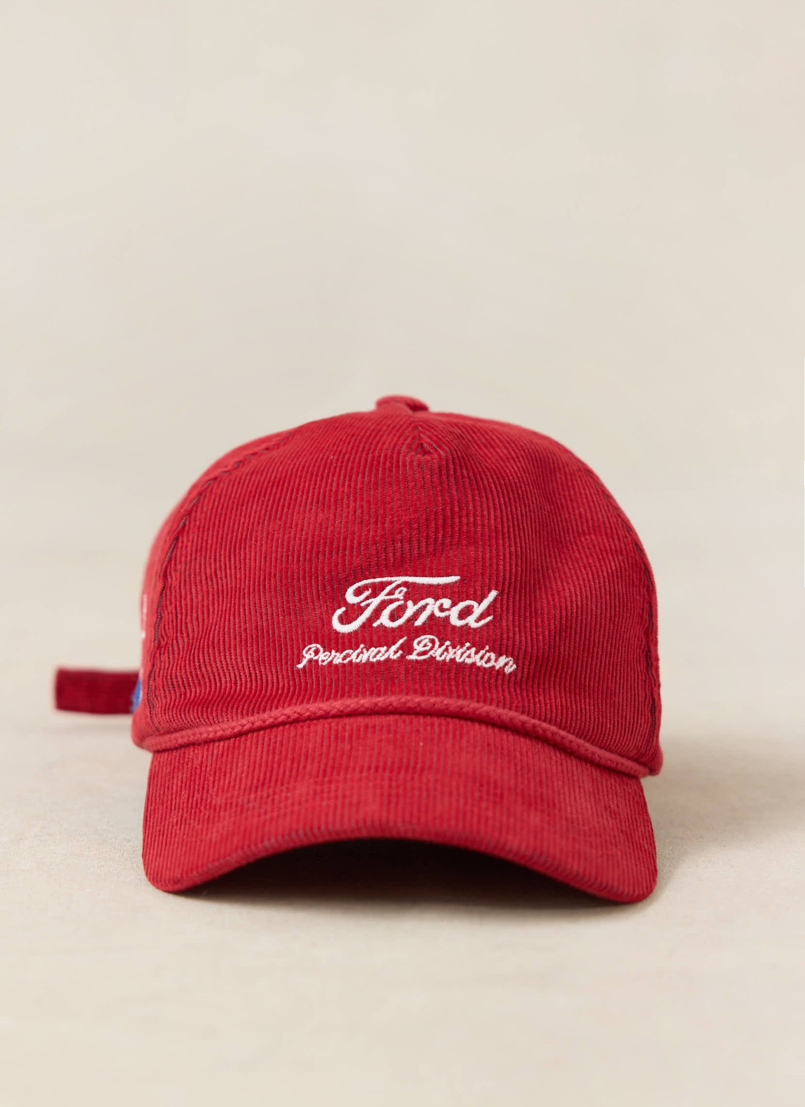 Red Ford x Percival corduroy soft trucker cap with white embroidered logo, shown on a neutral studio background.
