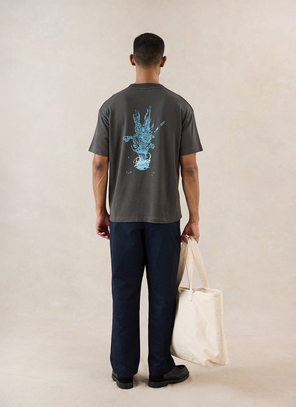 Charcoal Percival Dawson boxy t-shirt with a blue floral vase back graphic, shown from behind on a model.