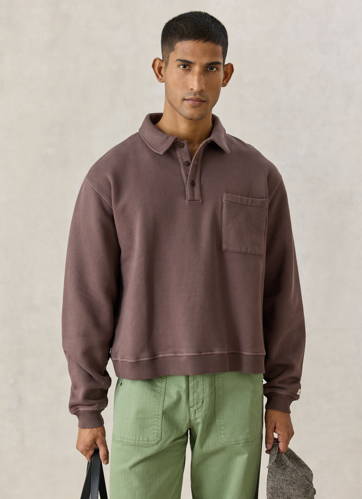 A model wearing the Percival brown cotton vintage wash popover boxy sweatshirt with a chest pocket and collared neckline.