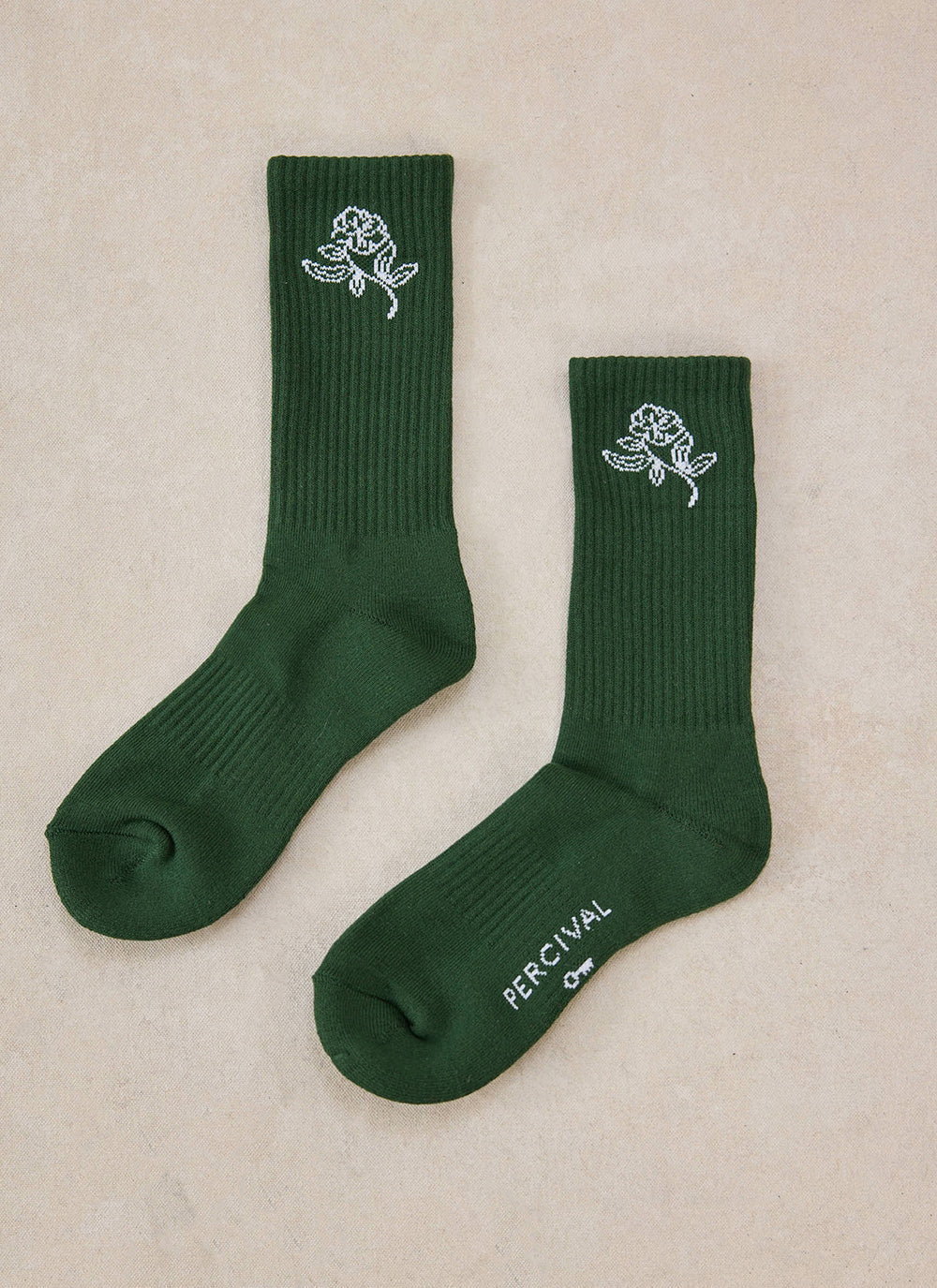 A pair of forest green Percival Earl Jacquard socks with white floral patterns.