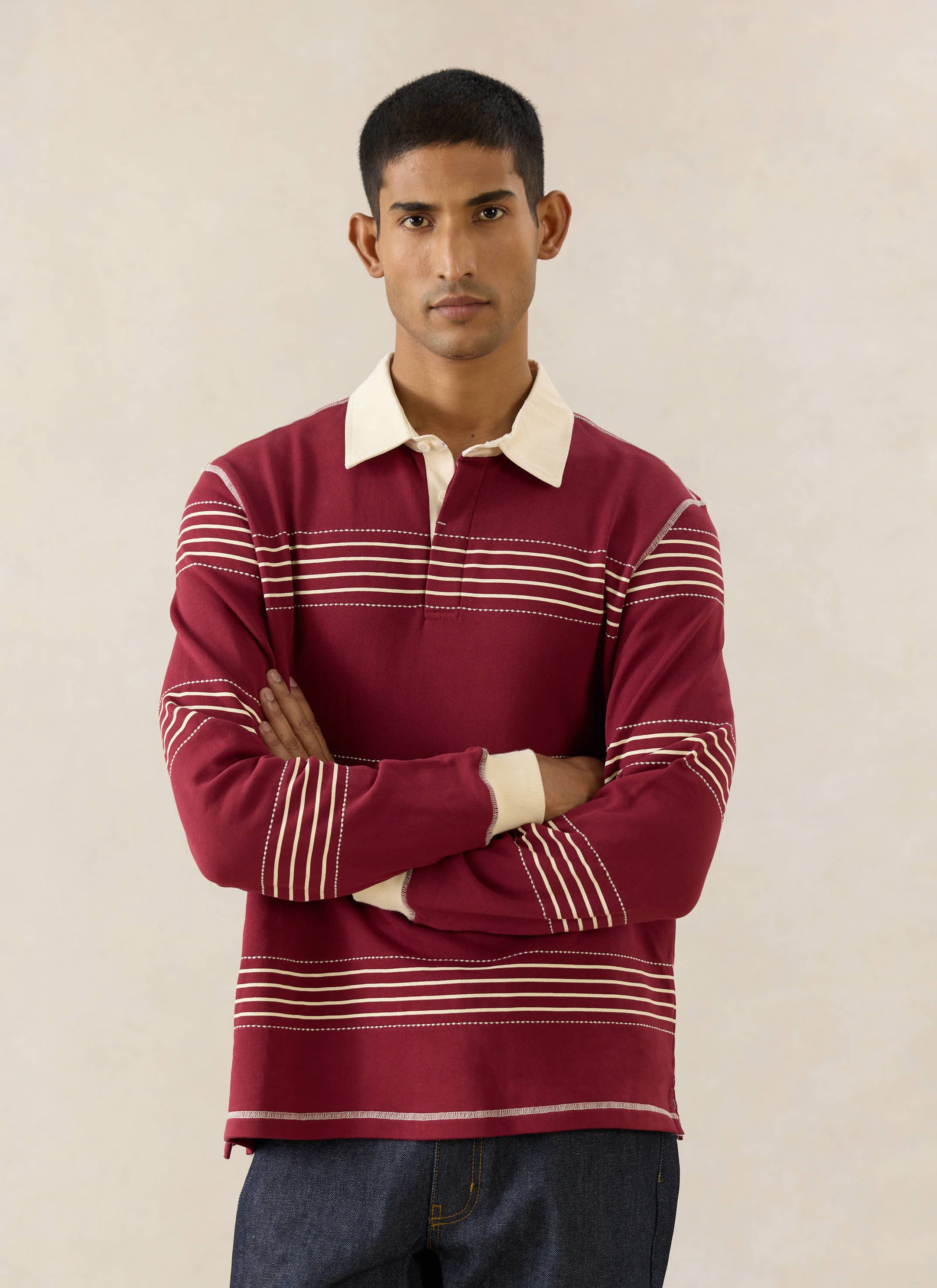 The Percival Editor Striped Rugby Polo in burgundy cotton with cream collar and stab stitched stripes and raw indigo denim.
