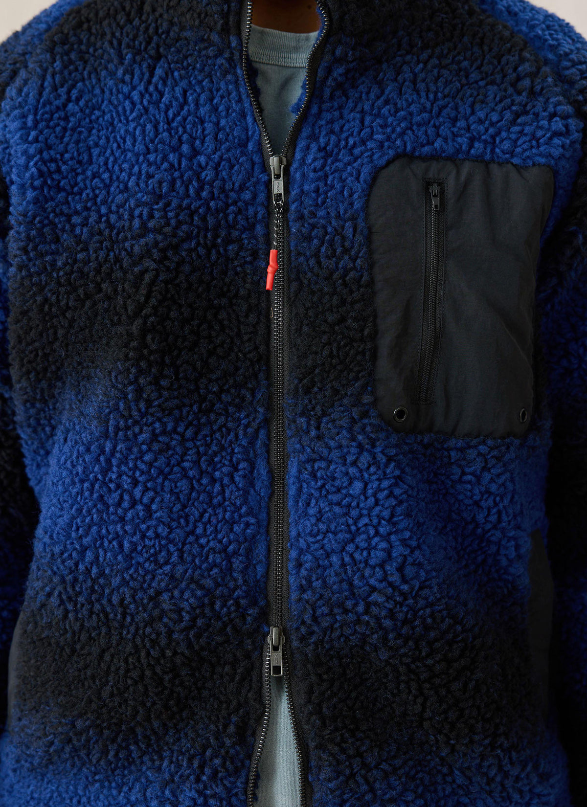 Close-up of the Percival ombre blue fleece jacket highlighting textured fabric and chest pocket.
