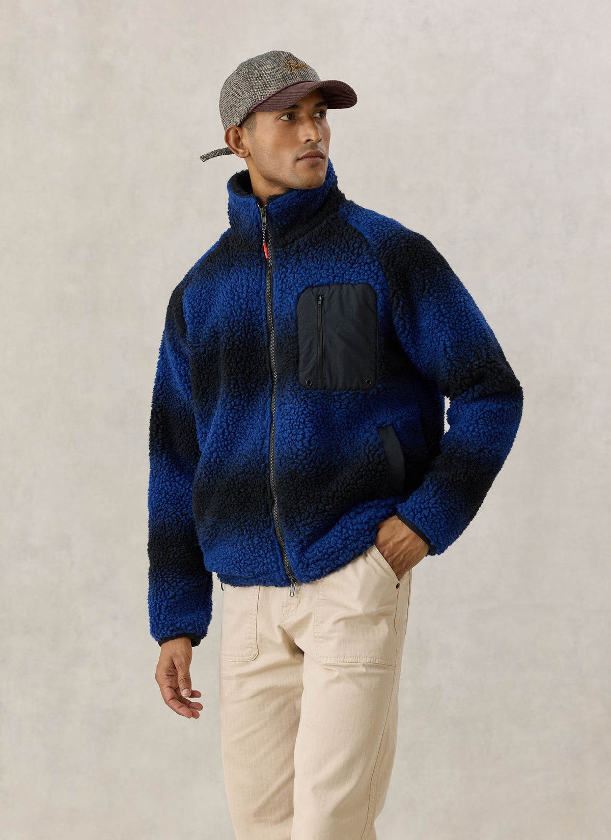 A model wearing the Percival ombre blue wool-blend fleece jacket with a stand collar and zipped chest pocket.