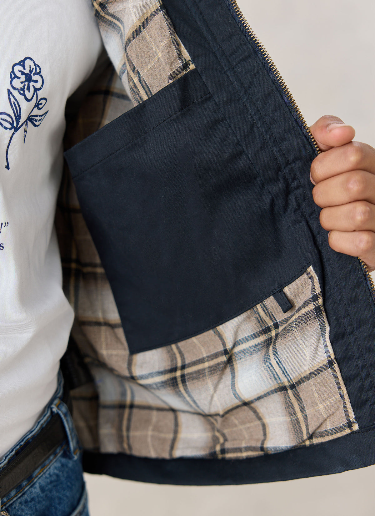 A close-up of the navy Fletcher Utility Fleece Wax Jacket showing the interior pocket and patterned lining.